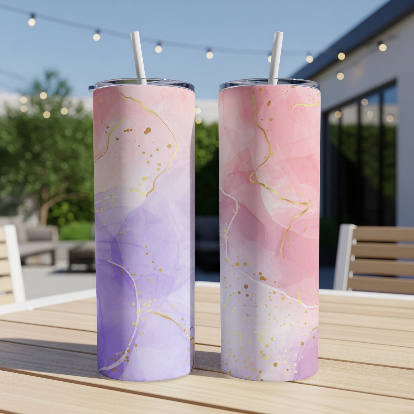 Two tumblers with watercolor and gold splatter patterns on a table.