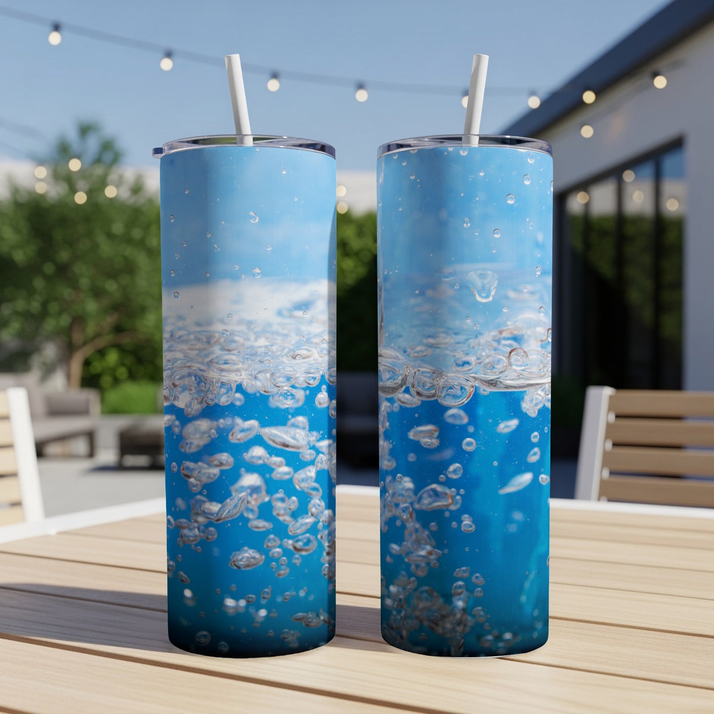 Two tumblers with a blue bubble and water splash design sit on a table.