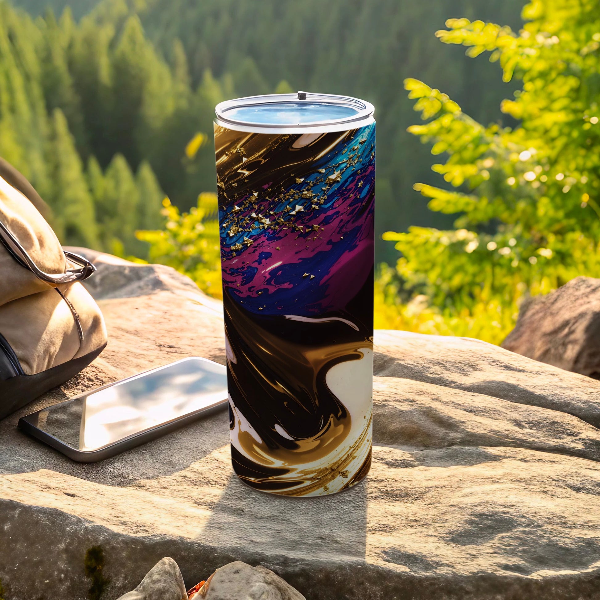 Tall tumbler with abstract blue, purple, and gold swirl design on a rock.