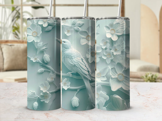 White bird perched on a branch with embossed flowers on a tumbler.