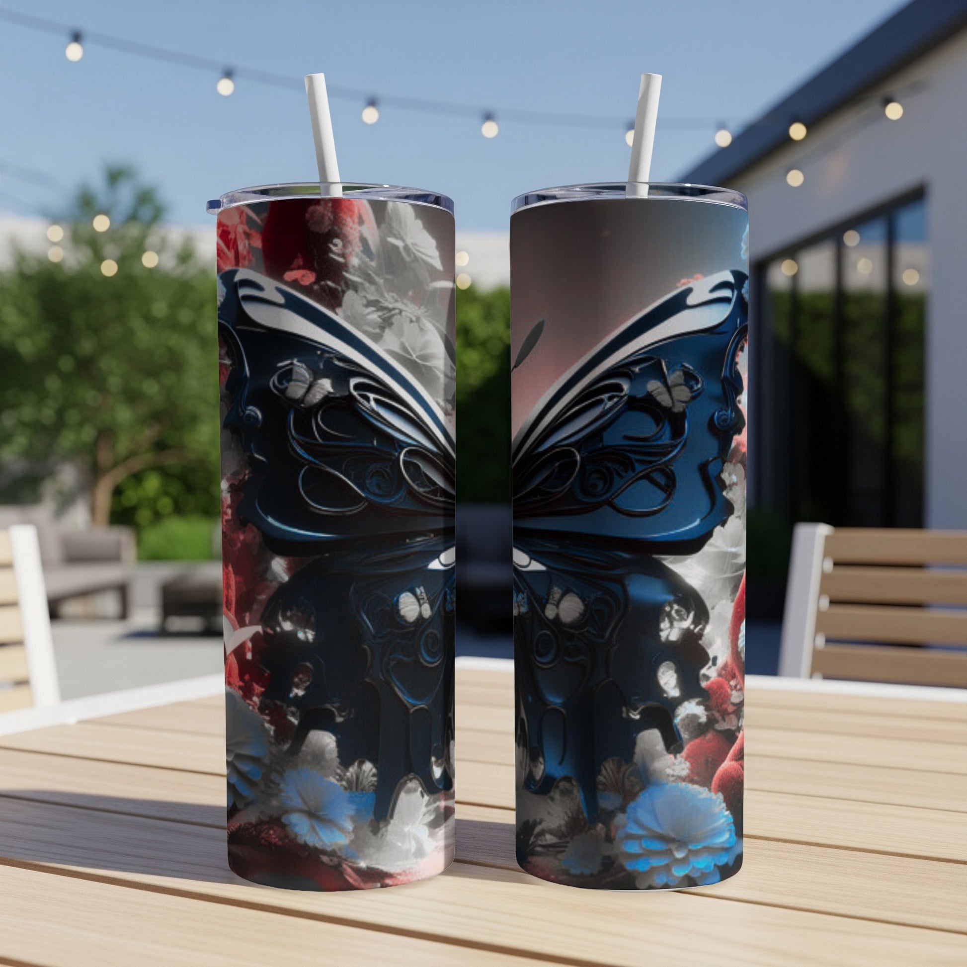 Two tumblers with a dark butterfly and floral design on a patio table.