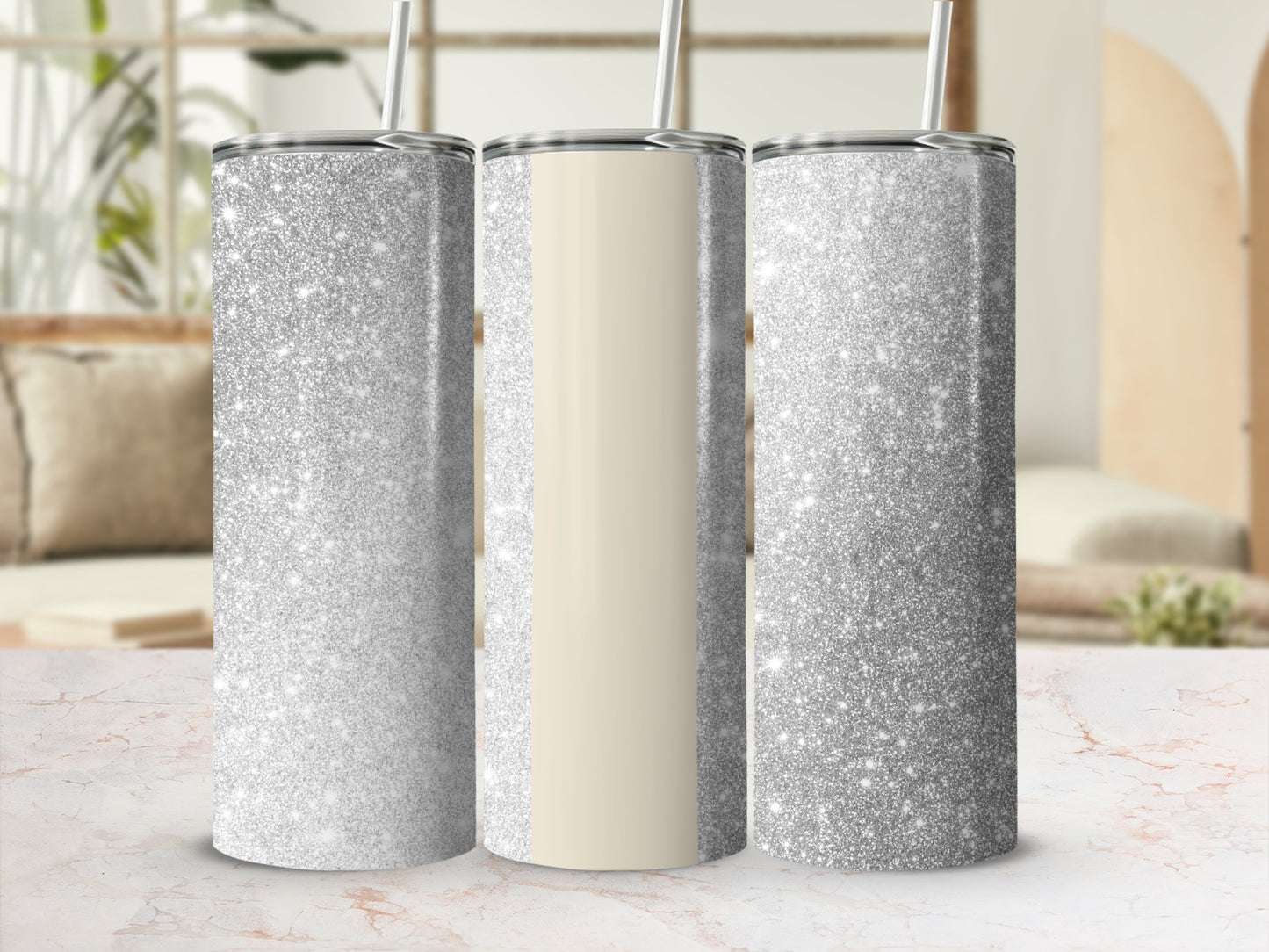 Three silver glitter tumblers with a cream stripe on a marble surface.