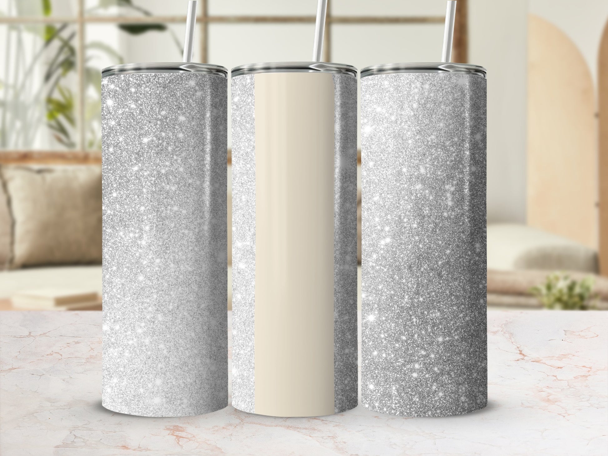 Three silver glitter tumblers with a cream stripe on a marble surface.