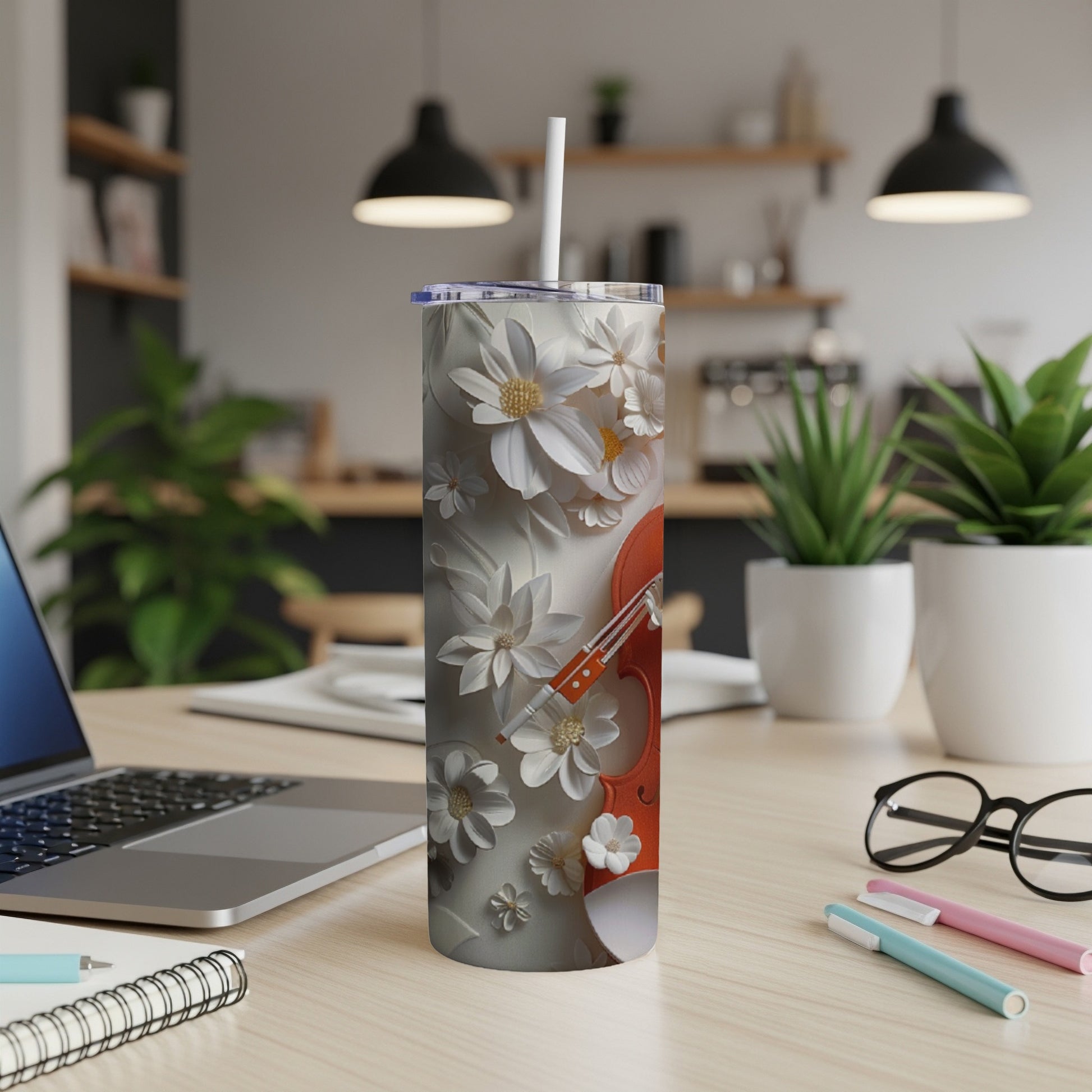 Orange violin with white floral patterns on a tumbler with a straw.