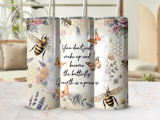Floral tumbler with bees, butterflies, and motivational quote.
