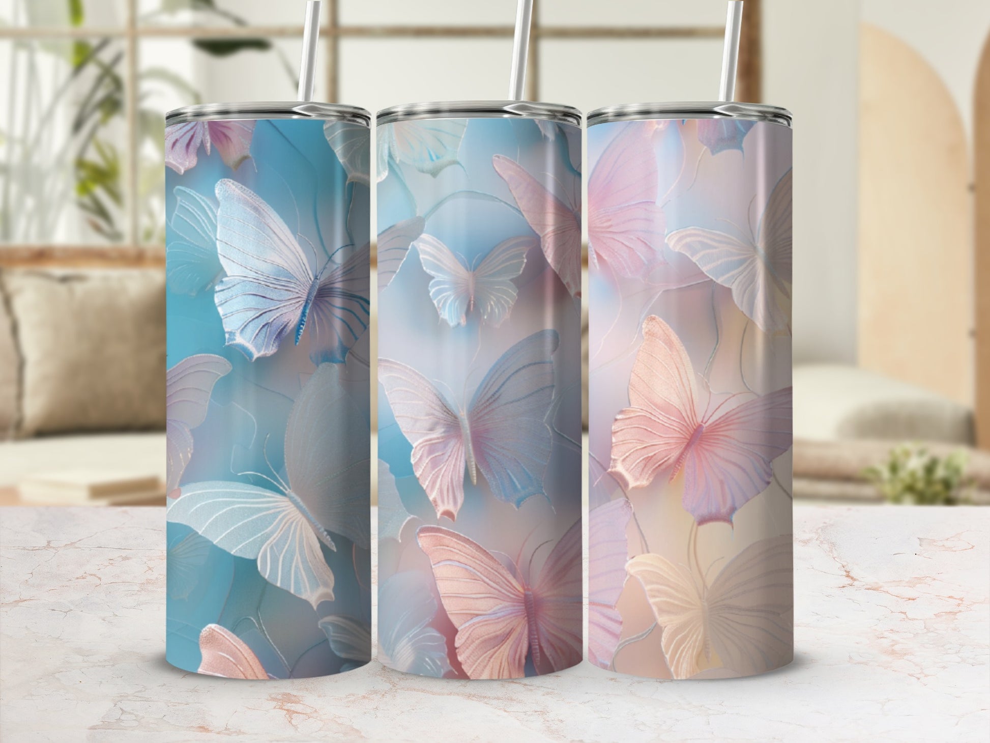 Three tumblers with pastel butterfly designs and straws.