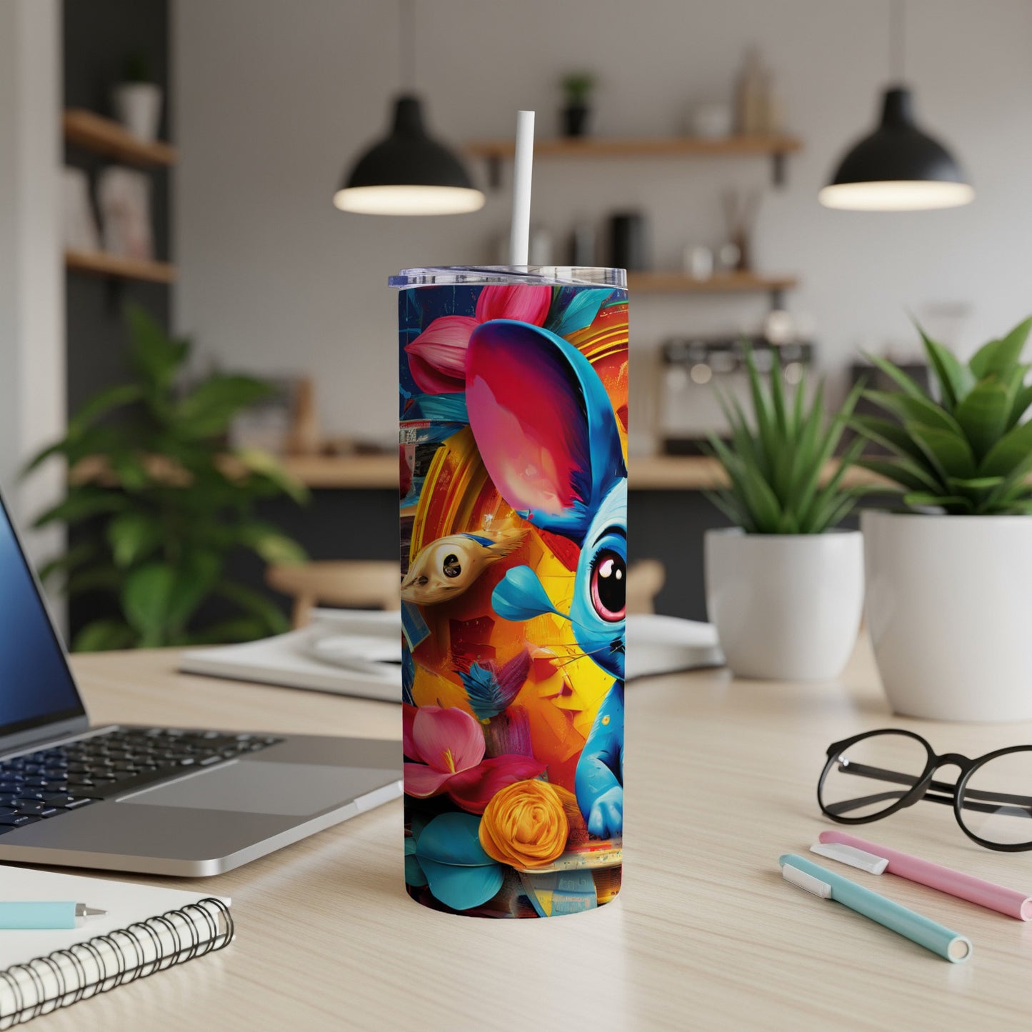 Cartoon character on a colorful floral tumbler with a straw, on a desk.