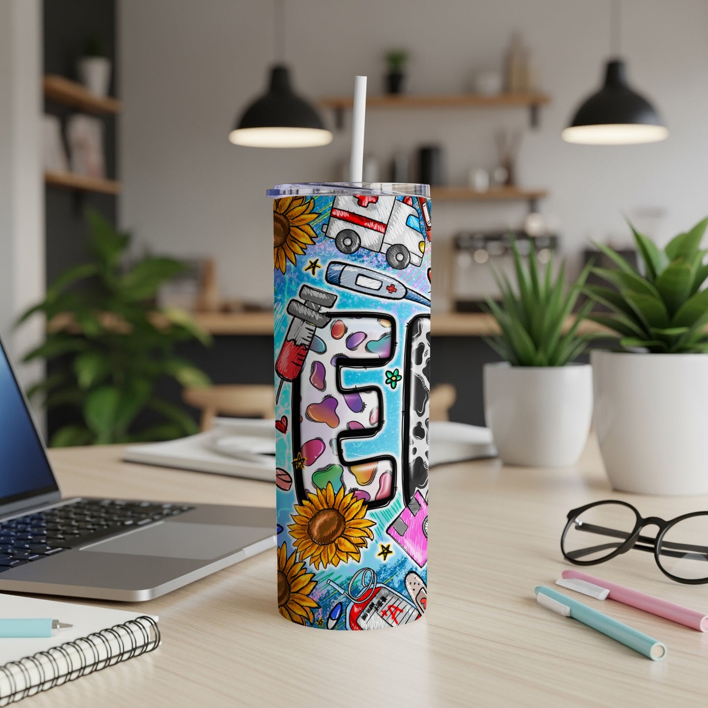 Tall tumbler with medical and sunflower designs, featuring a stylized "E".