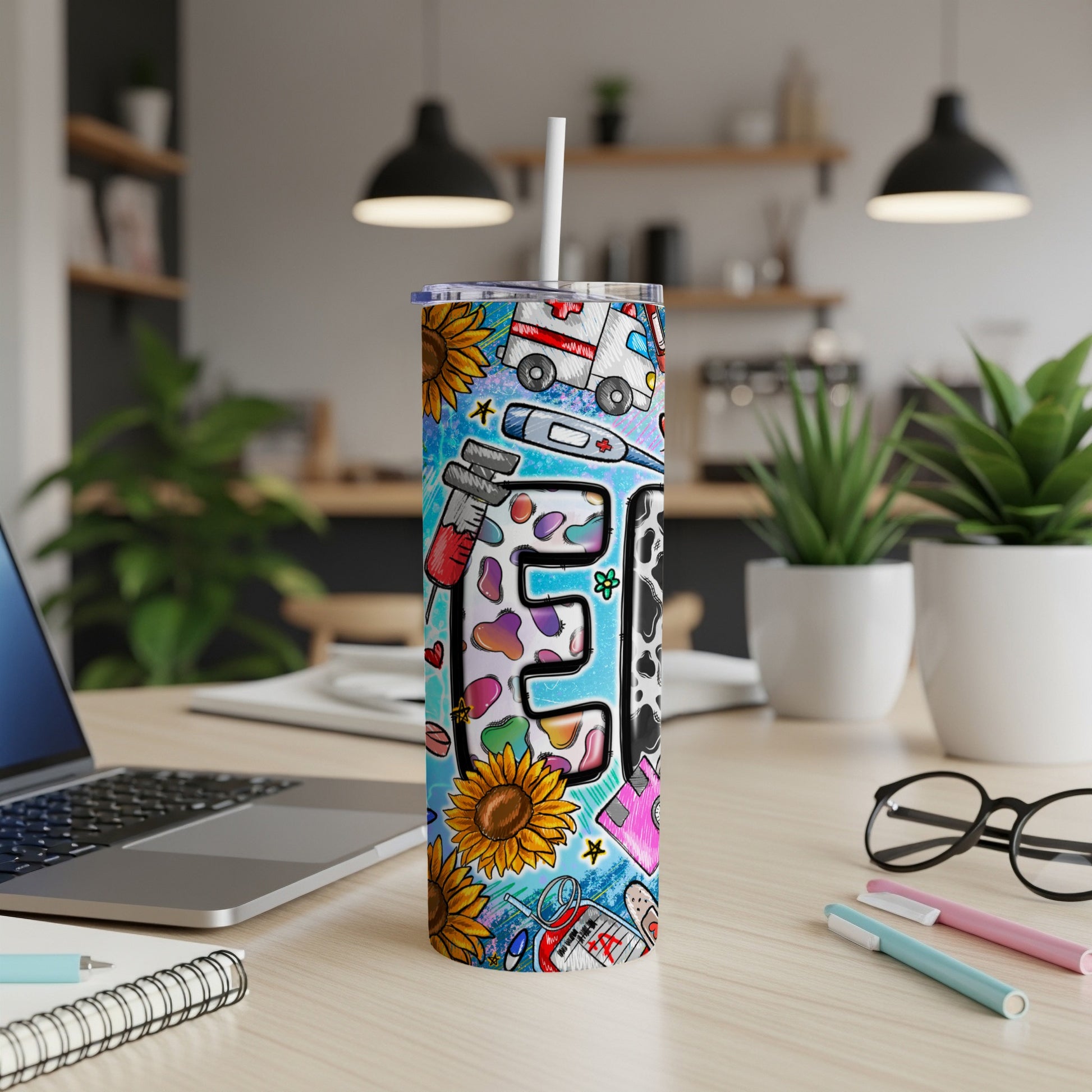 Tall tumbler with medical and sunflower designs, featuring a stylized "E".