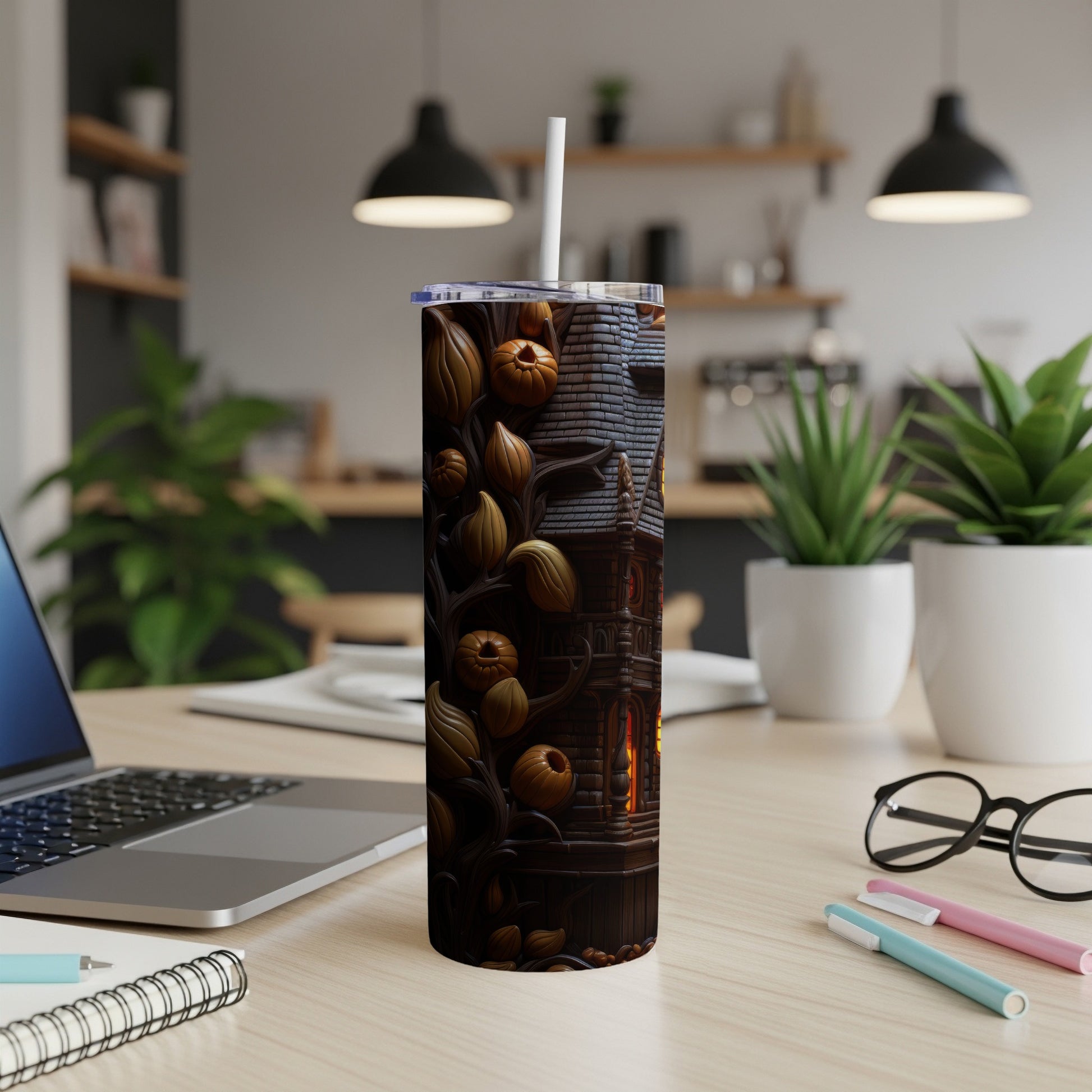 Tumbler with Halloween haunted house and pumpkin design, featuring a white straw.