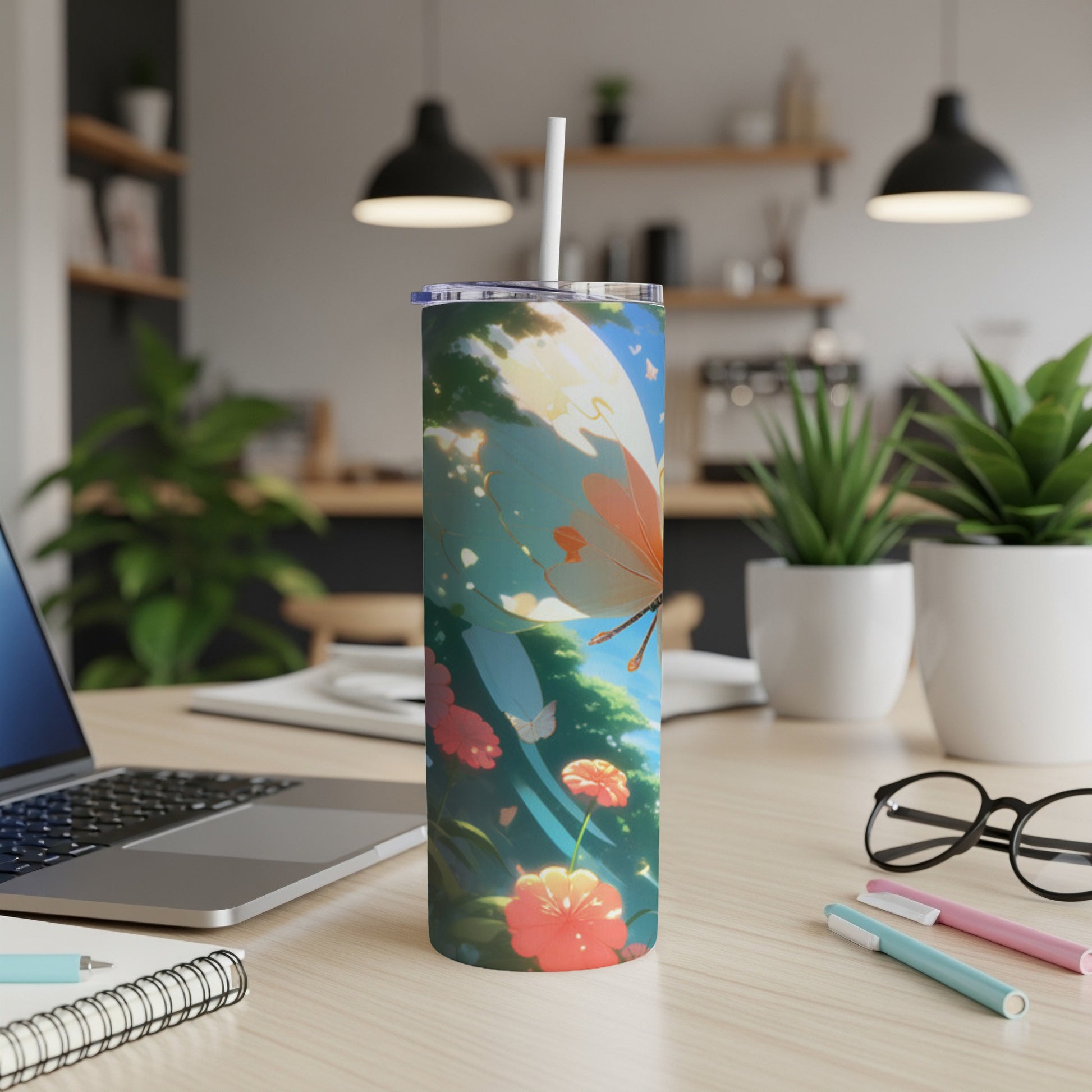 Tall tumbler with butterfly and floral design on desk.