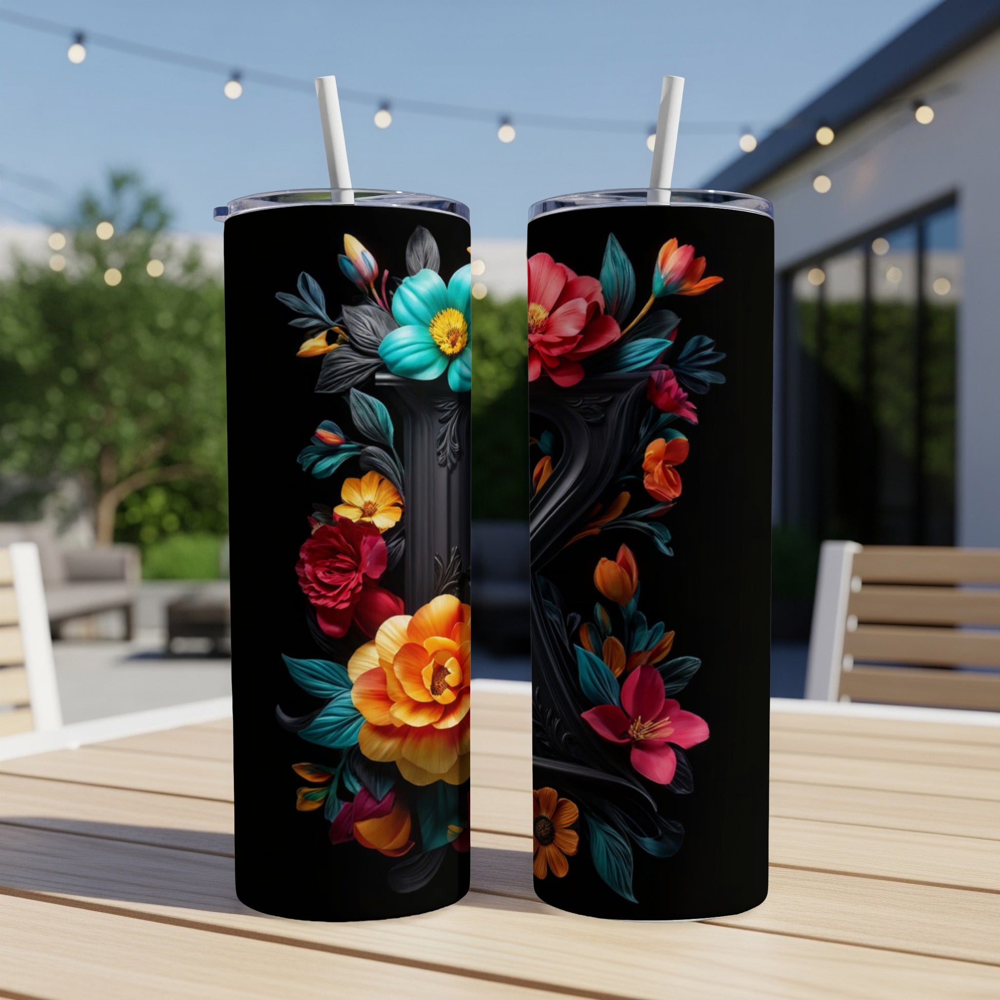 Two tall tumblers with vibrant floral designs on a wooden table.
