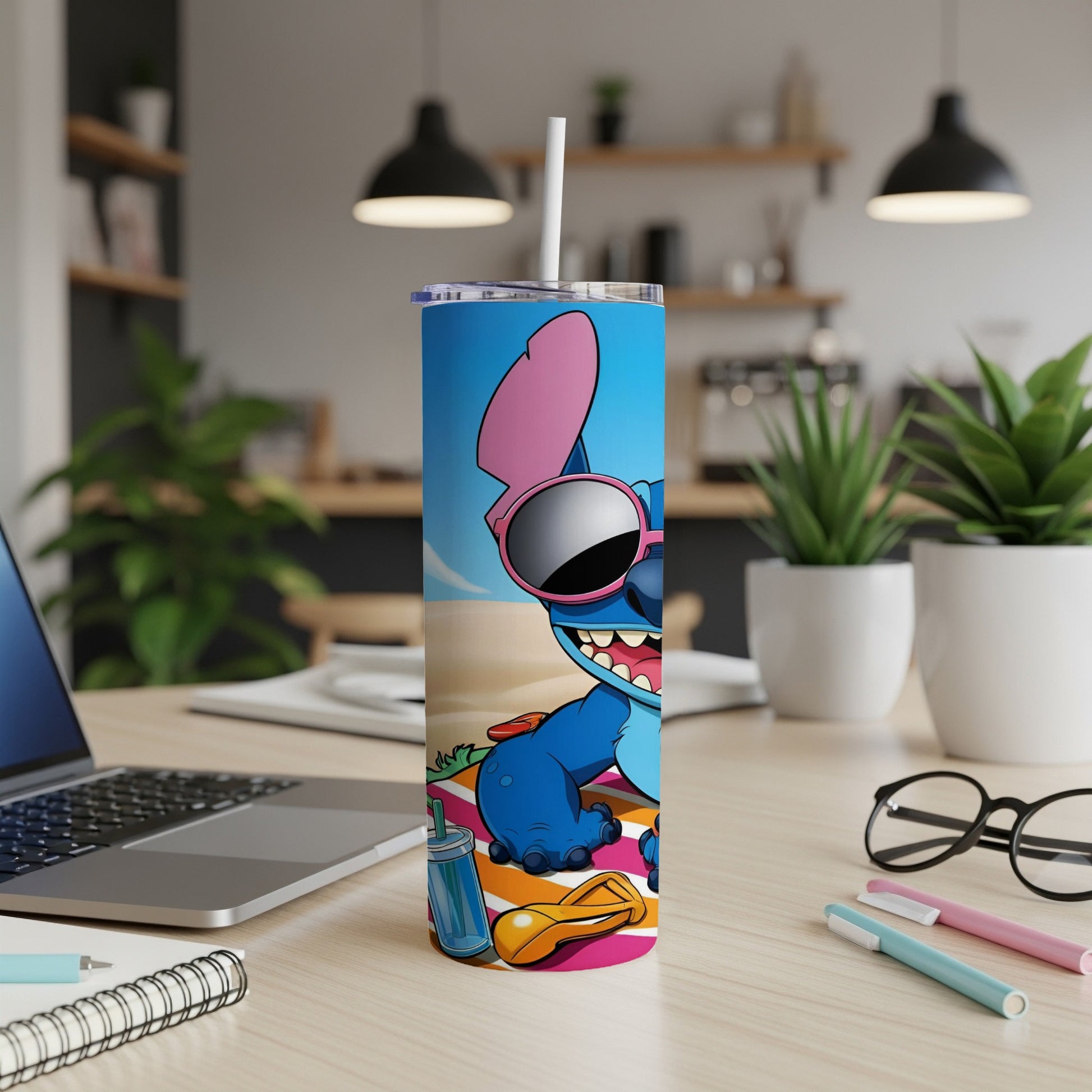 Stitch in sunglasses sitting on a beach towel with a drink and flip-flops.