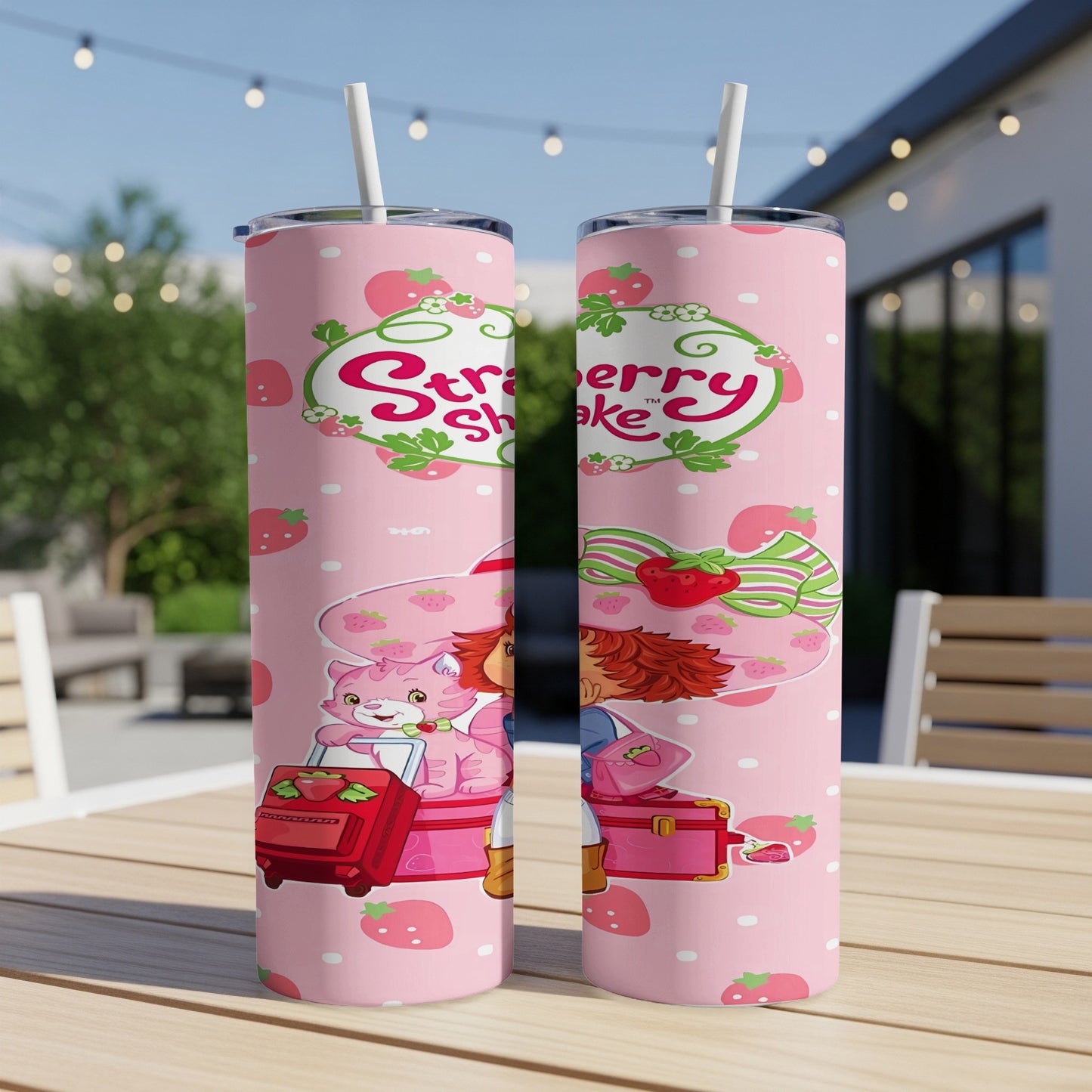 Strawberry Shortcake tumbler with straw on a pink background with strawberries.