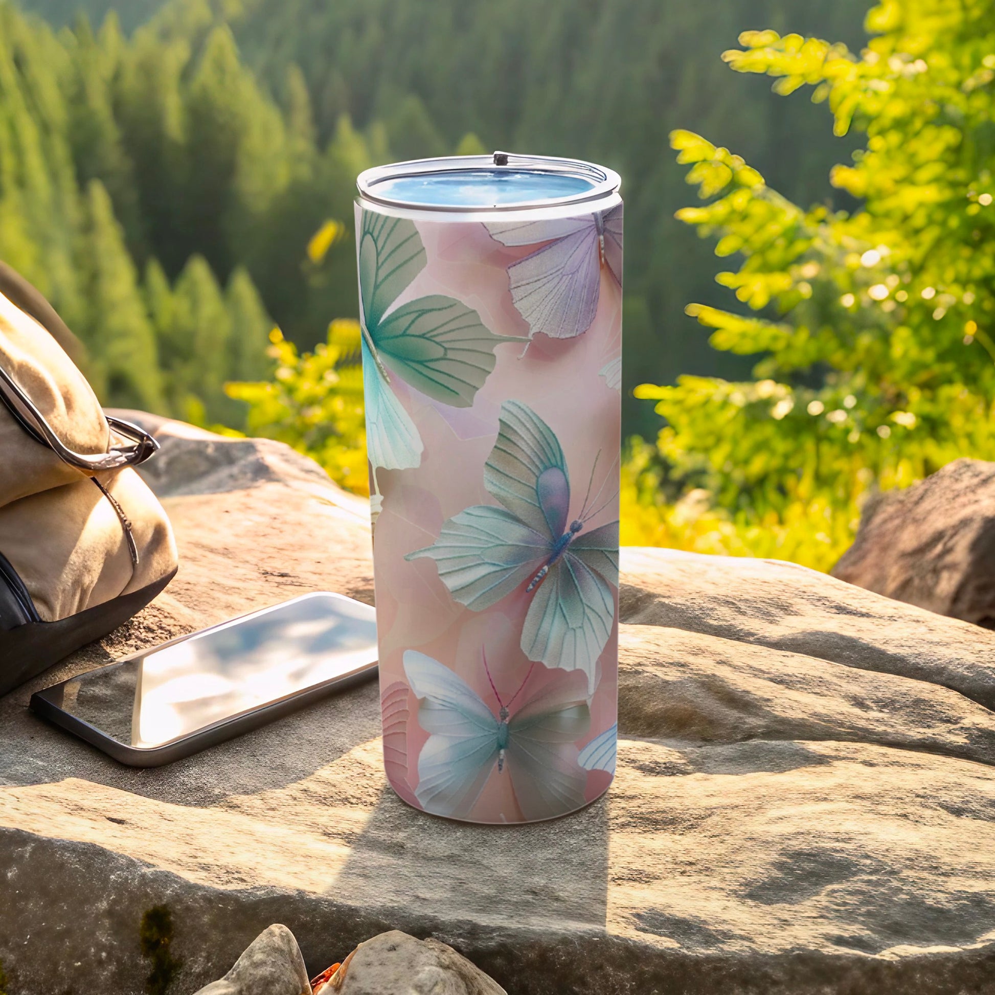 Tumbler with pastel butterflies and mountains in background.