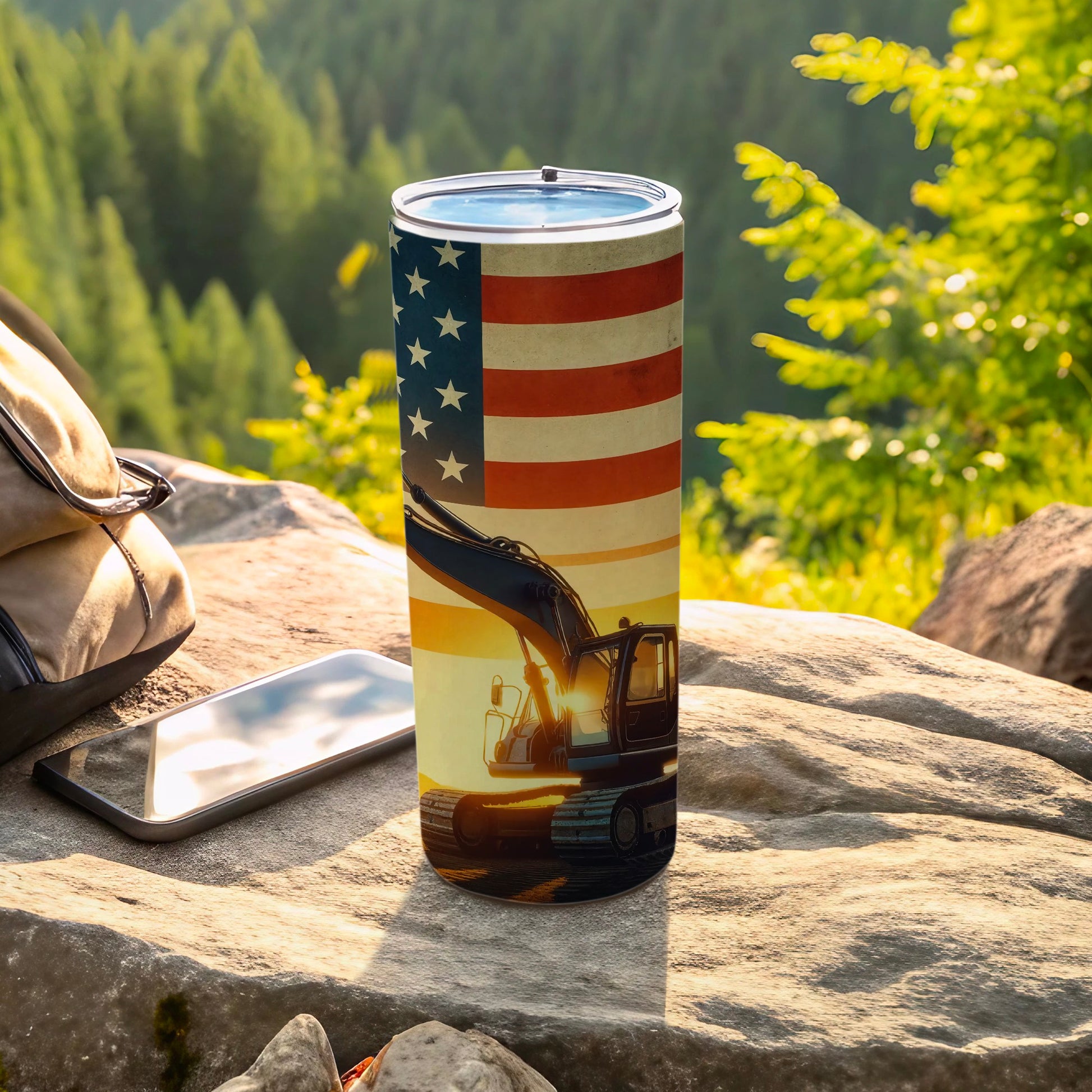 Tumbler with American flag and excavator design, outdoors.