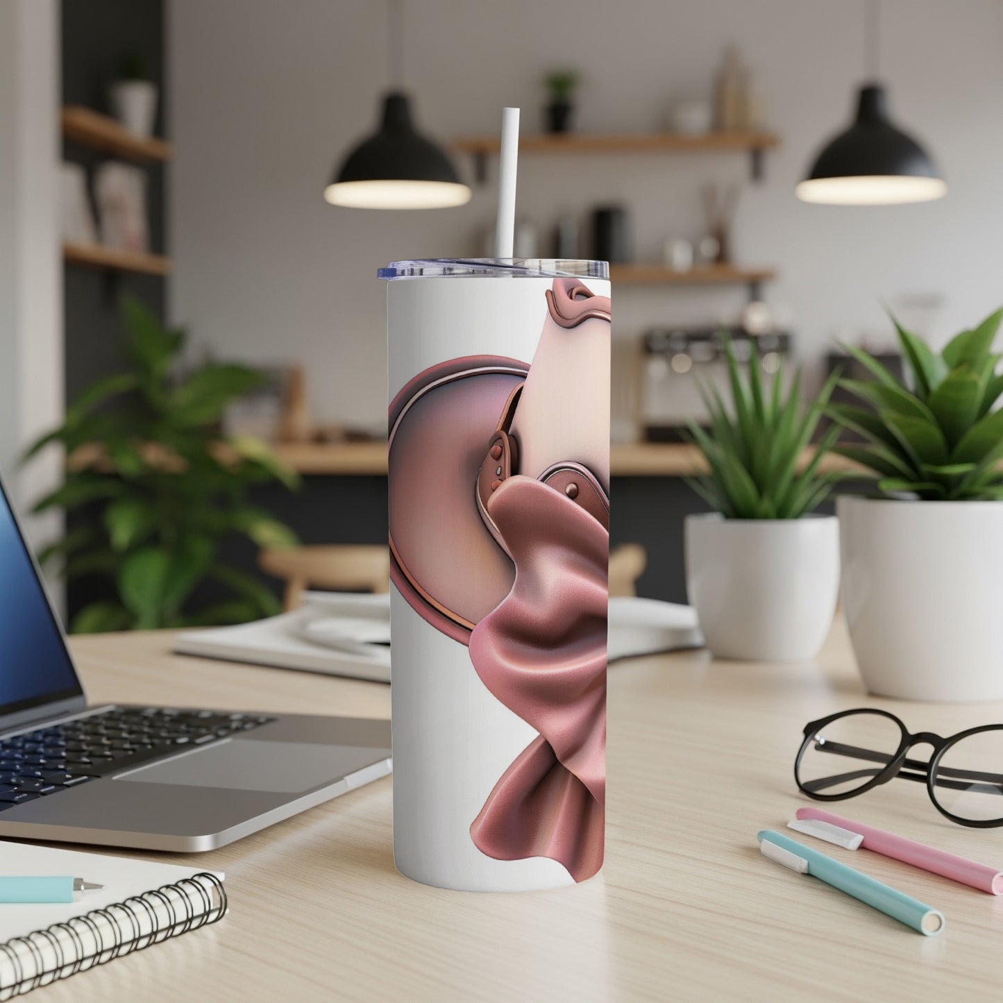 White tumbler with pink satin draped design on a desk.