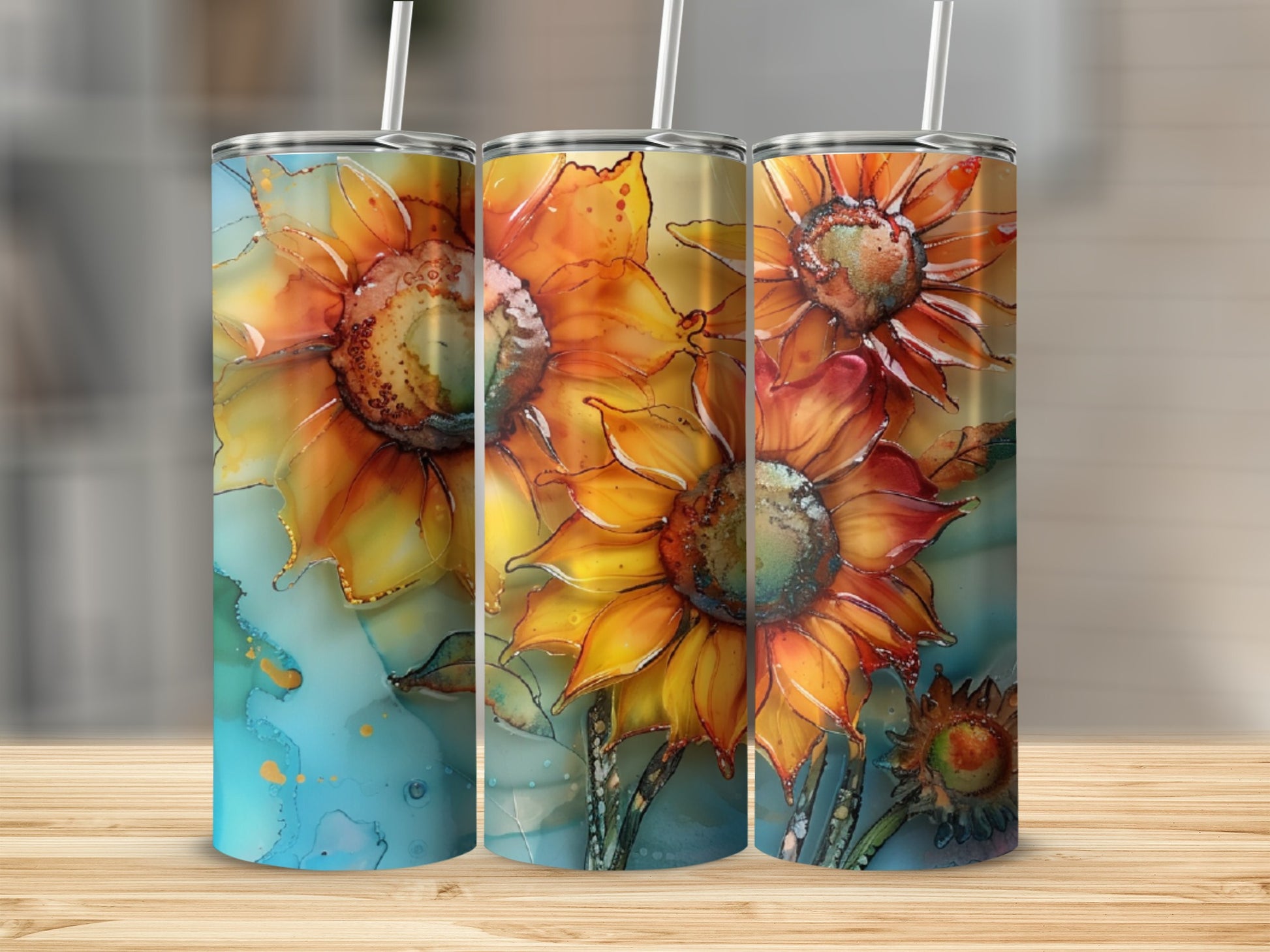 Three tumblers with watercolor sunflower designs on a wooden surface.