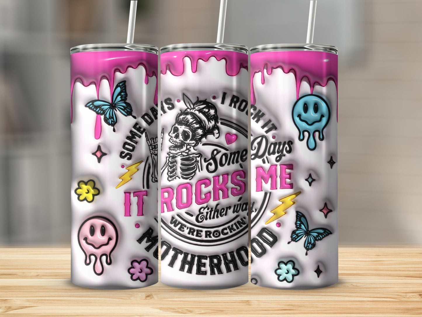 Pink dripping tumblers with skull, butterflies, and "Motherhood" text.