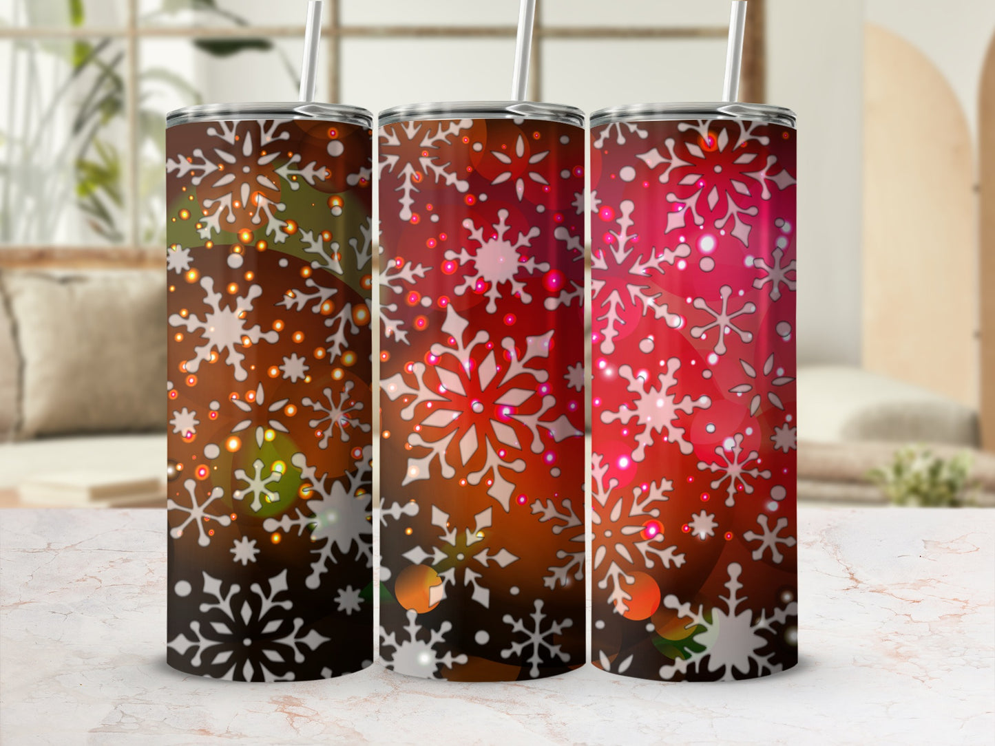 Three tumblers with snowflake and bokeh designs in red and brown.