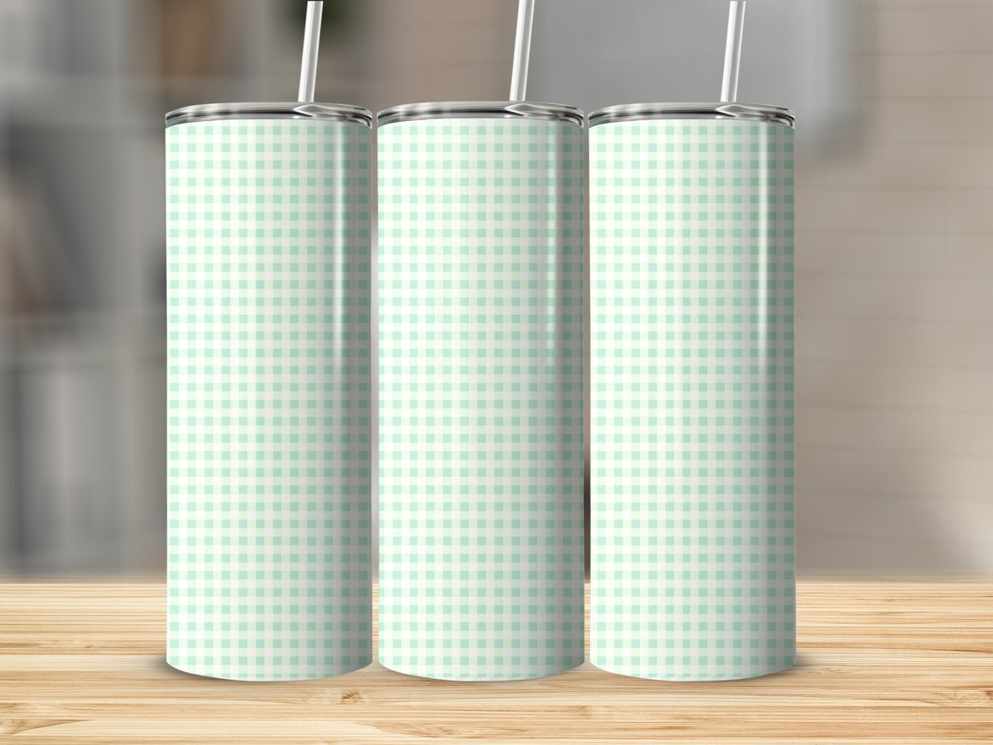 Three mint green and white gingham print tumblers with straws.