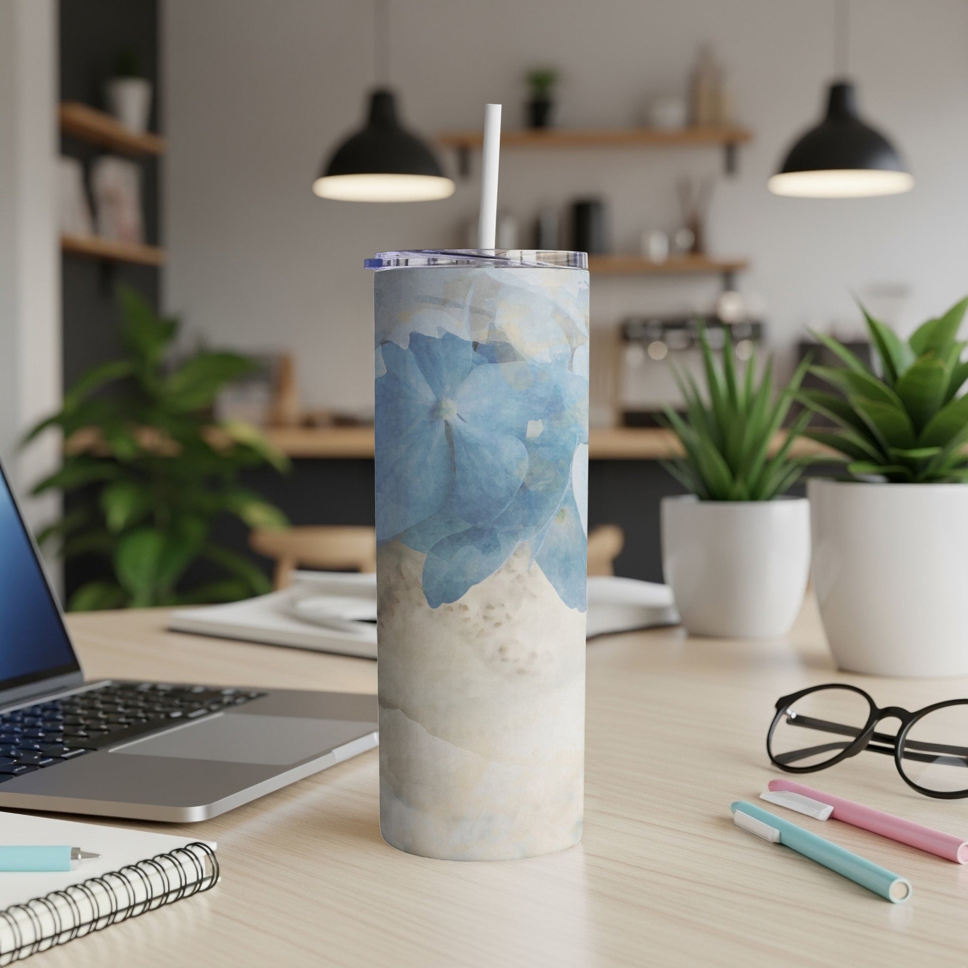 Blue floral tumbler with marble-like pattern on a desk.