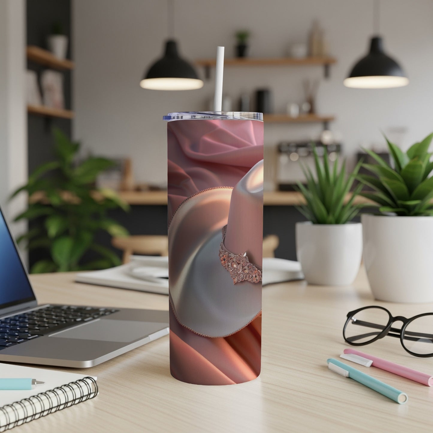 White ceramic mug with a decorative rose gold band on a pink satin cloth.