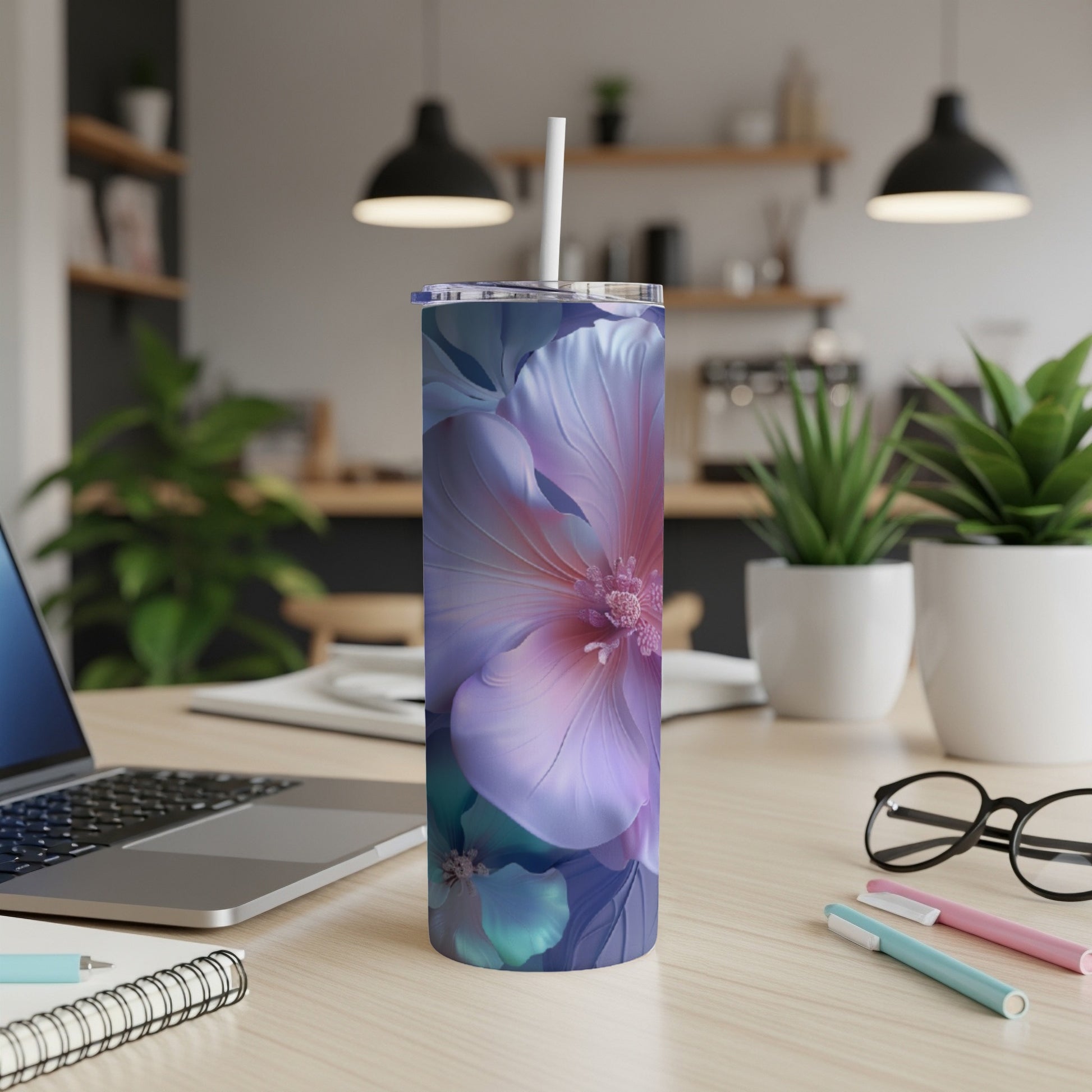 Tall tumbler with large pink and purple floral design on a desk.