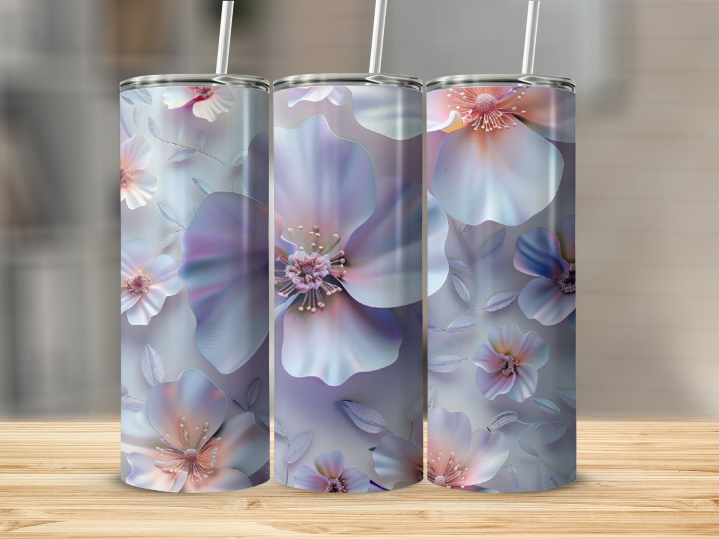 Three tumblers with floral sublimation design on wooden surface.