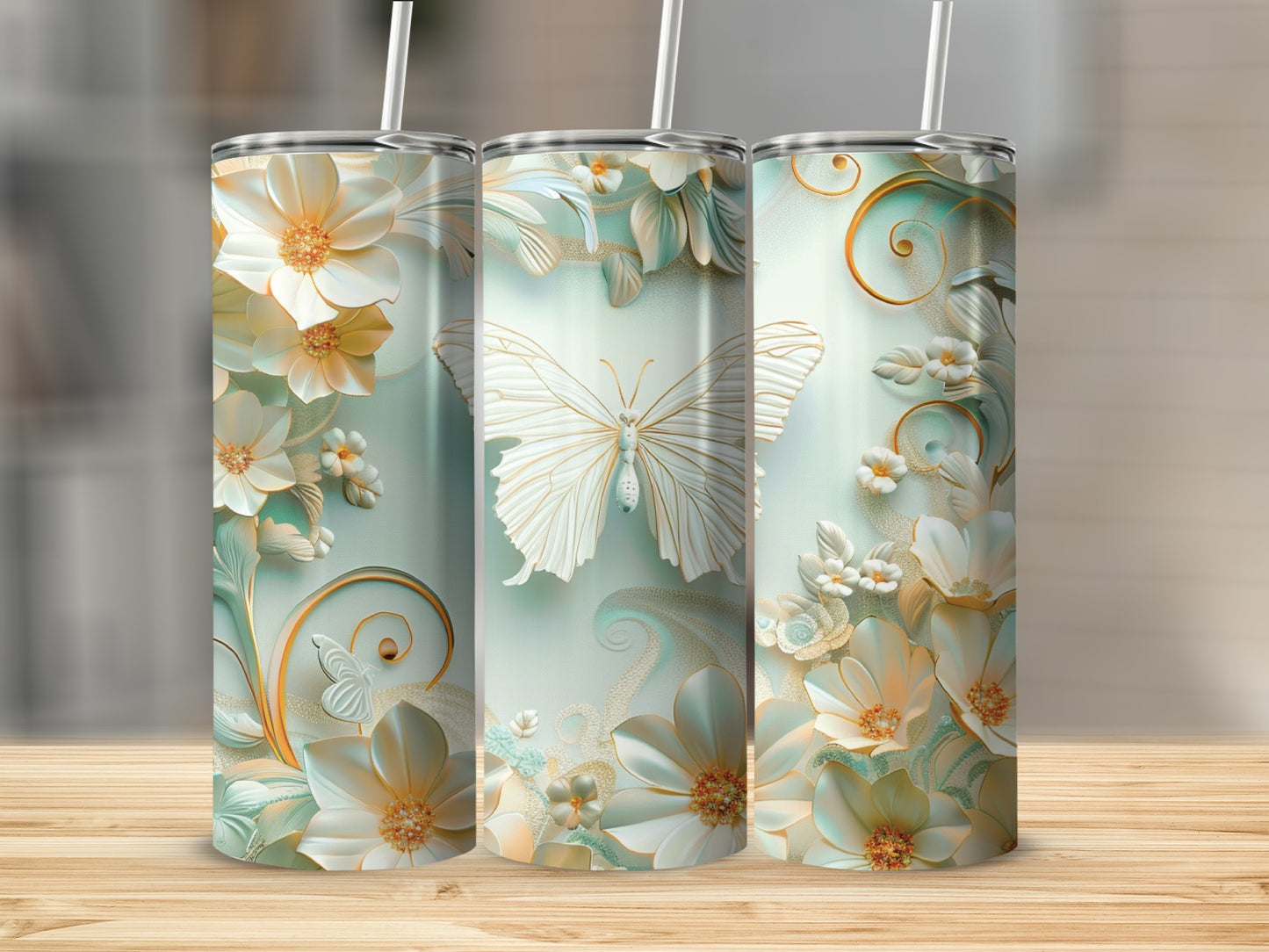 Three tumblers with intricate floral and butterfly designs in soft pastel colors.