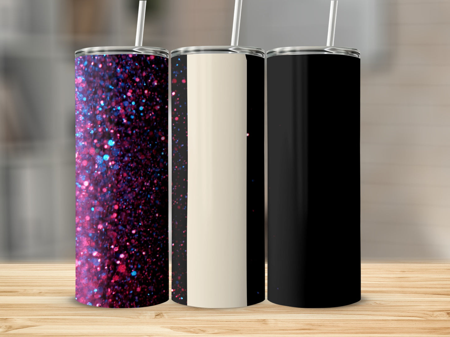 Three tumblers with patterned, cream, and black designs stand on a wooden surface.