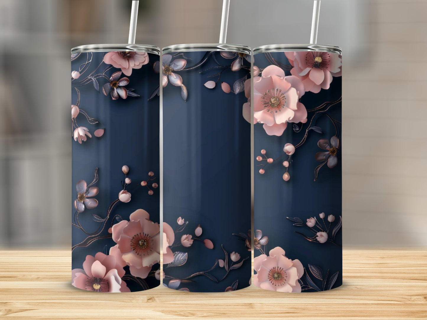 Three navy blue tumblers with delicate pink floral designs and straws.