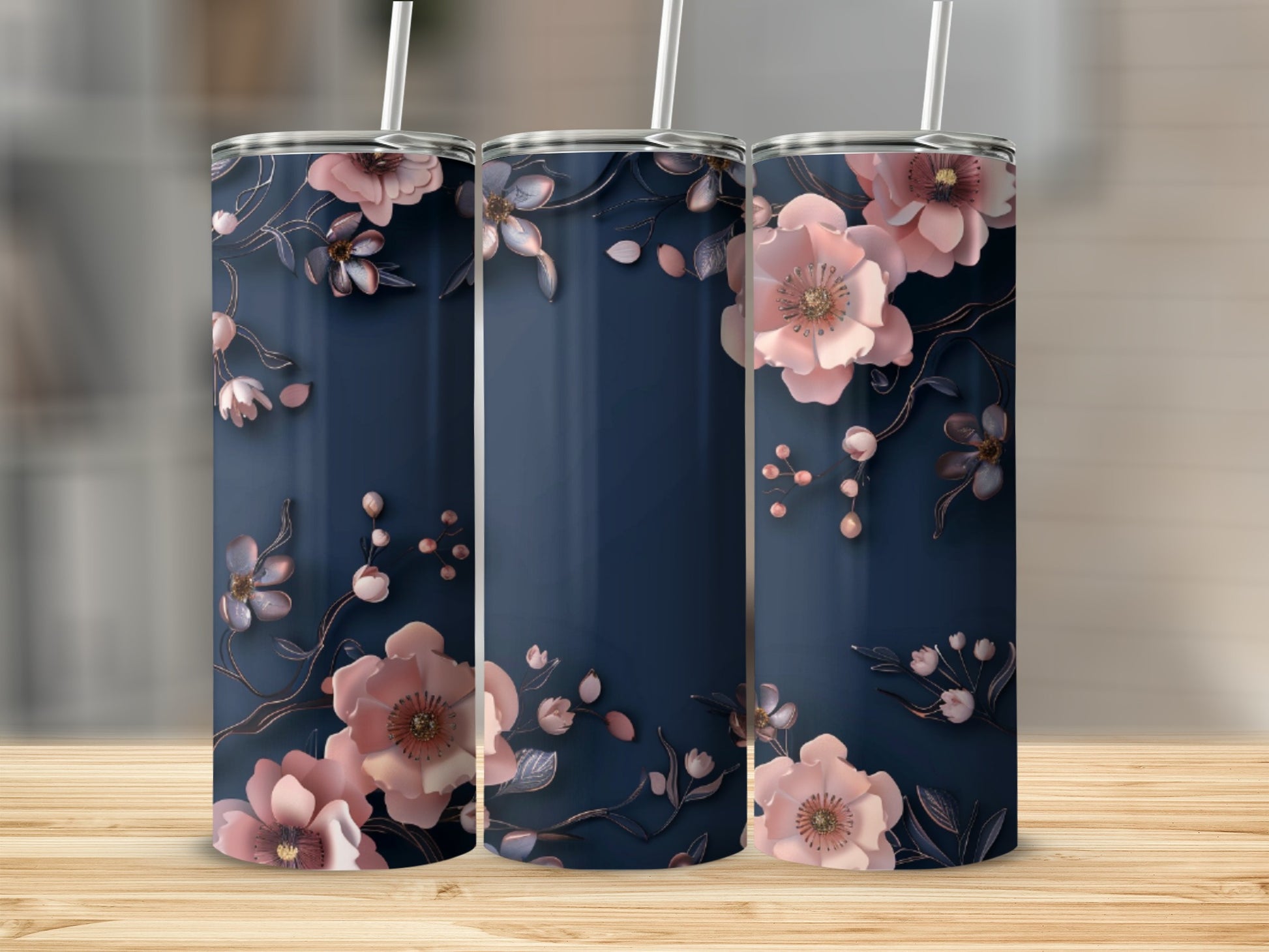 Three navy blue tumblers with delicate pink floral designs and straws.
