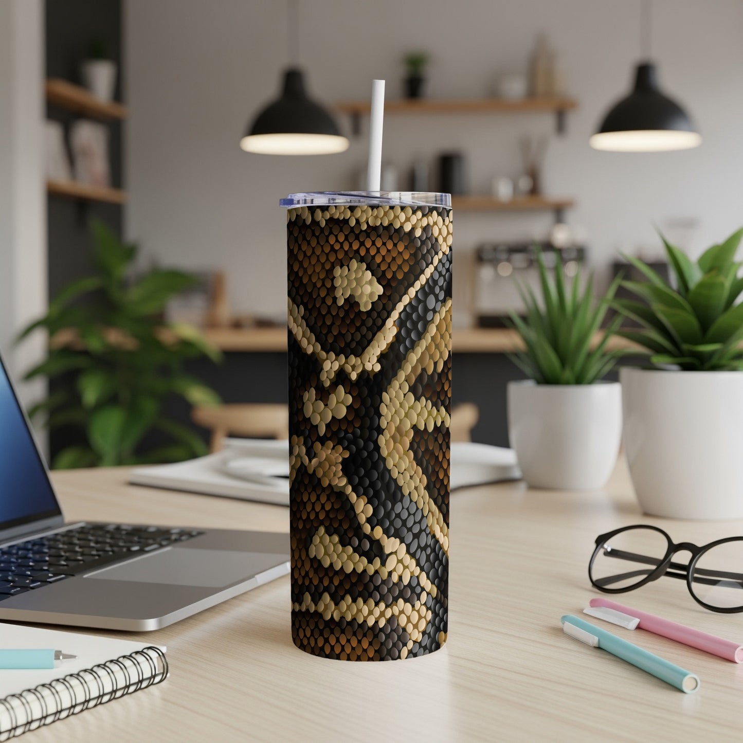 Tall tumbler with a brown and tan snakeskin pattern on a desk.