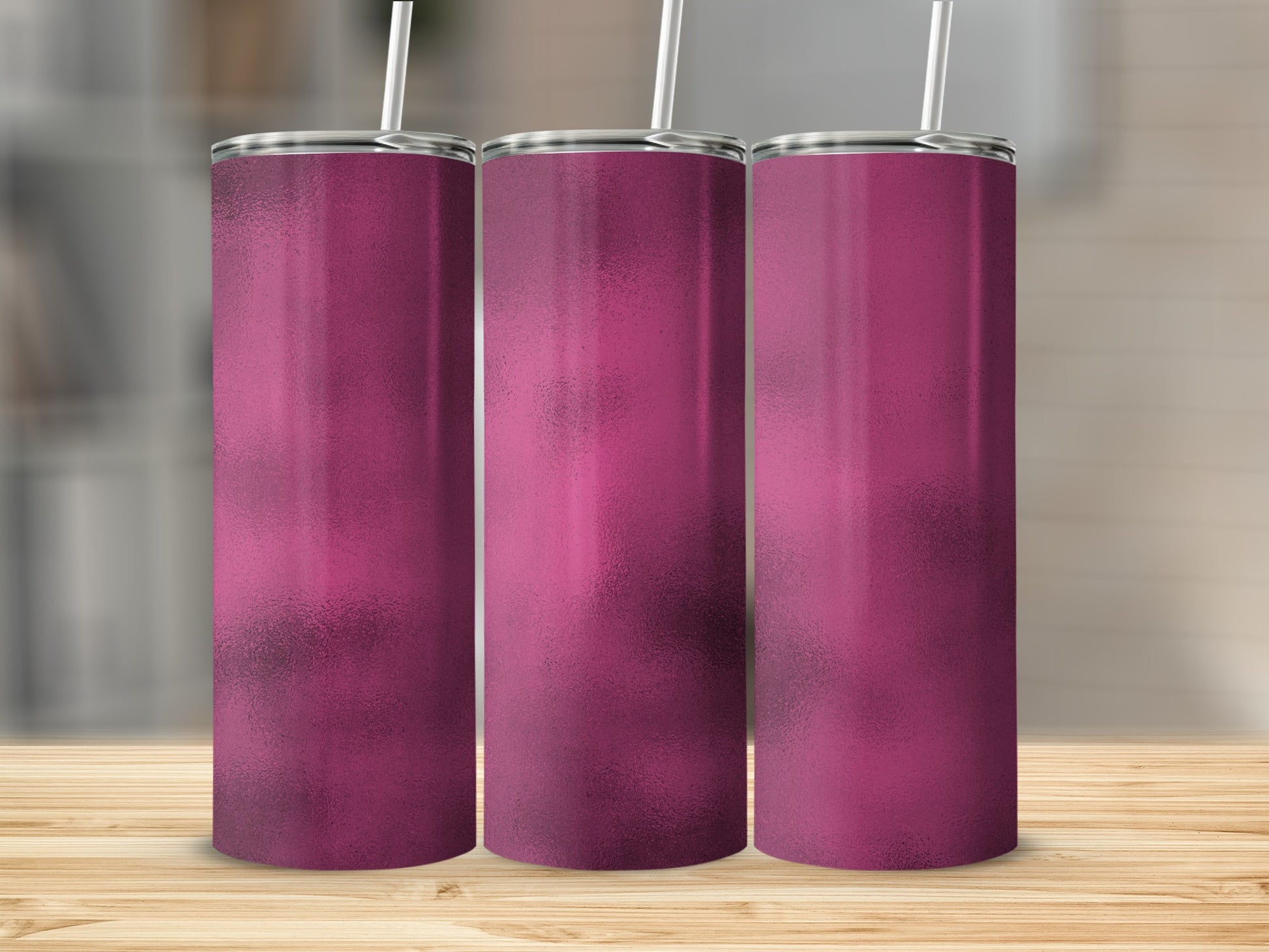 Three pink tumblers with straws on a wooden surface.