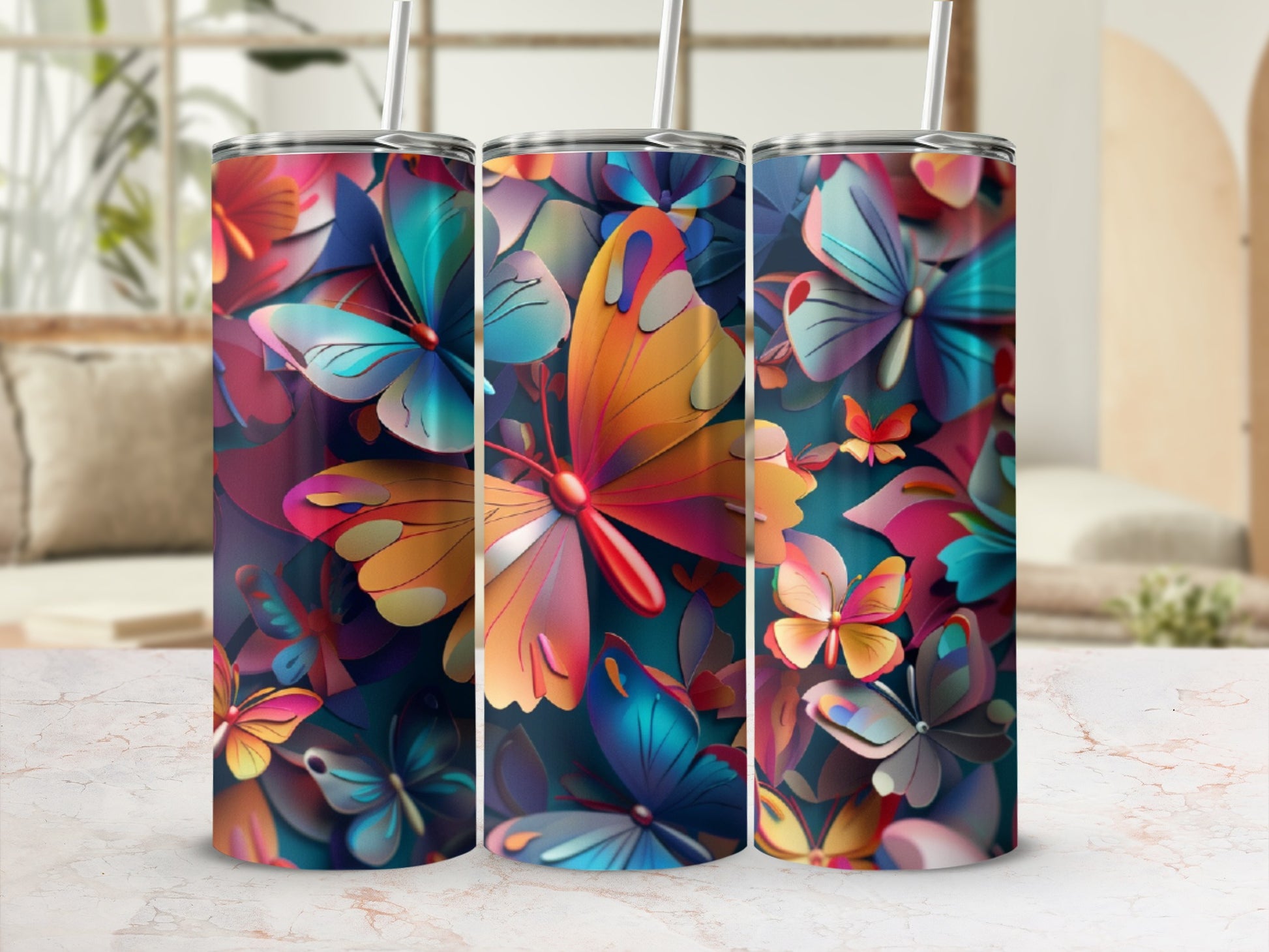 Colorful butterfly pattern on three tumblers with straws.