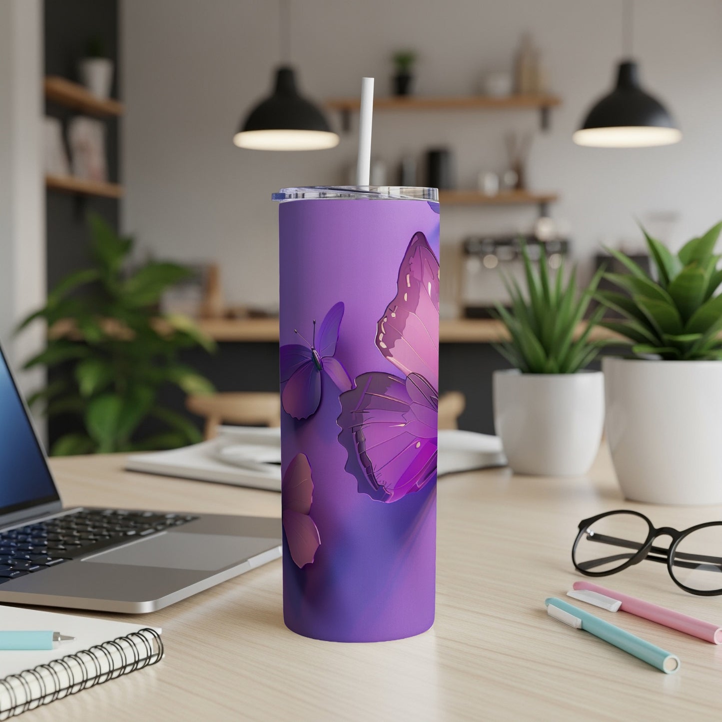 Purple tumbler with butterfly design, straw, and office desk background.