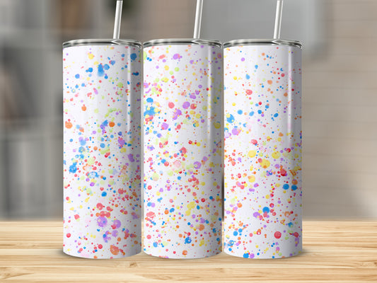Three white tumblers with colorful paint splatter design on wooden surface.