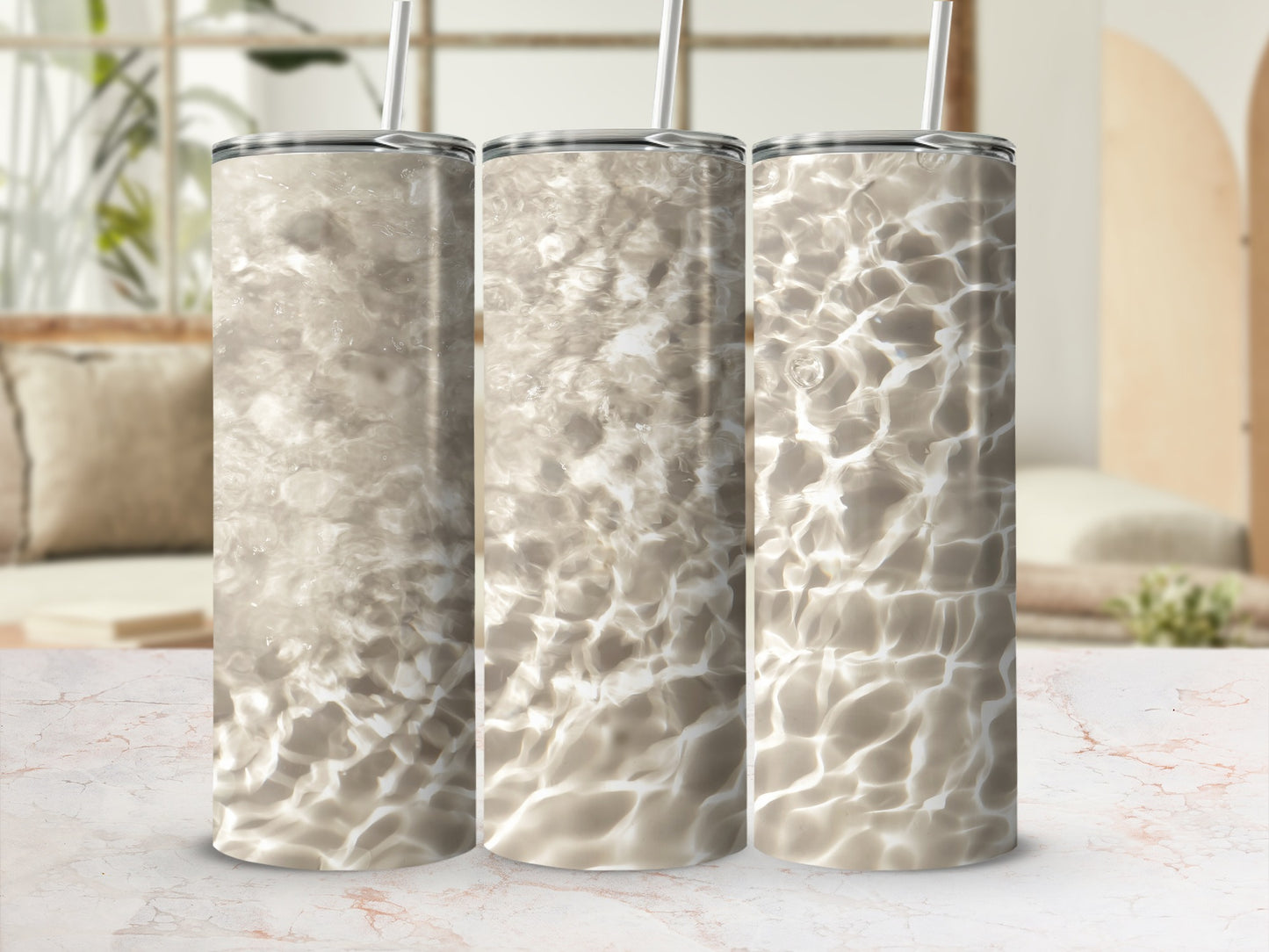 Three tumblers with a water ripple pattern against a blurred living room background.