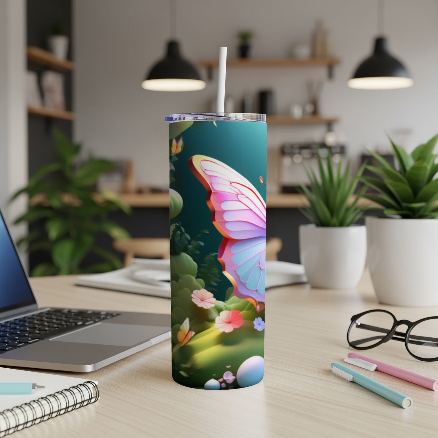 Tumbler with a butterfly and floral design, on a desk.