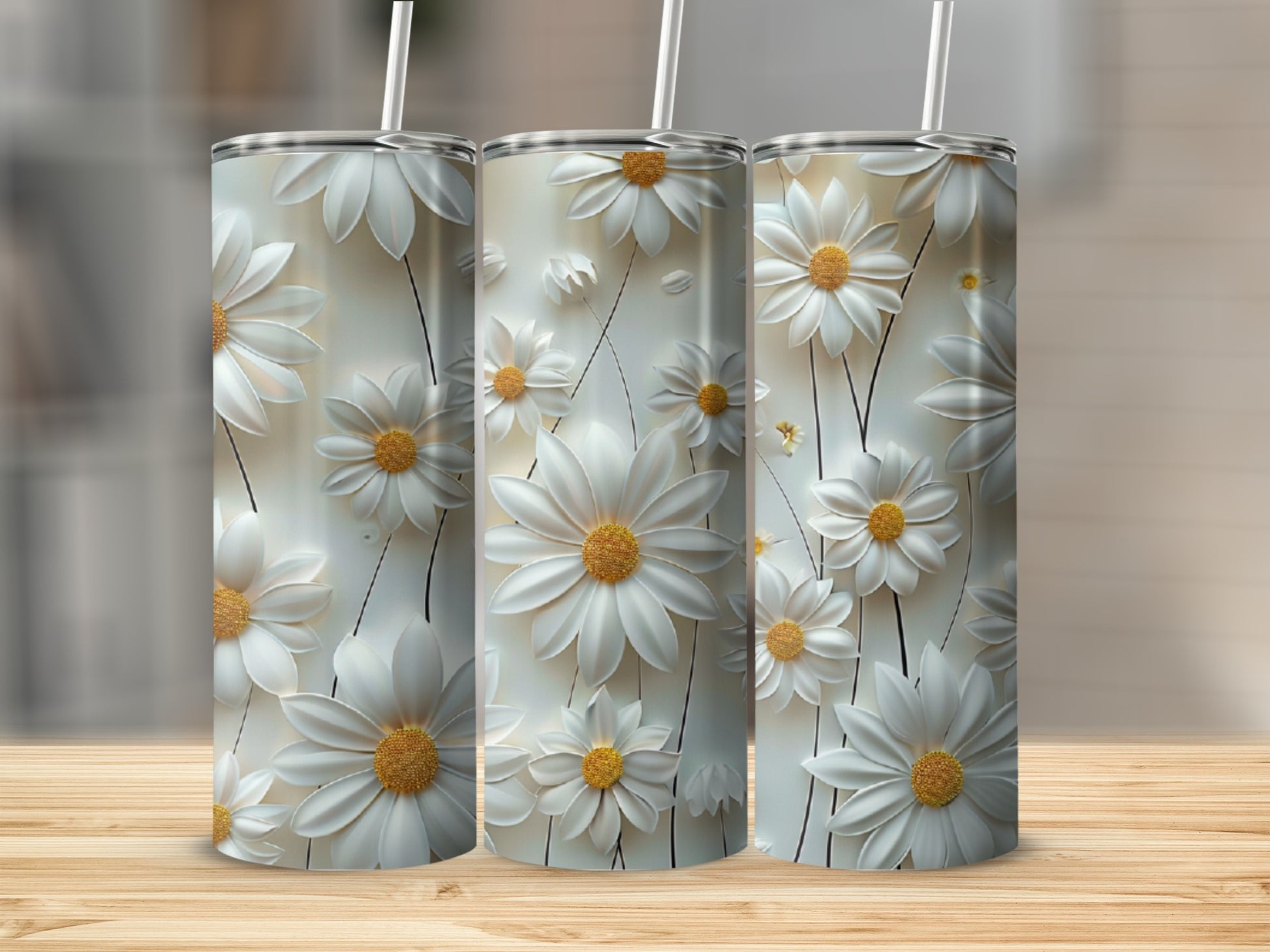 Three tall tumblers with white daisy floral patterns on a wooden surface.