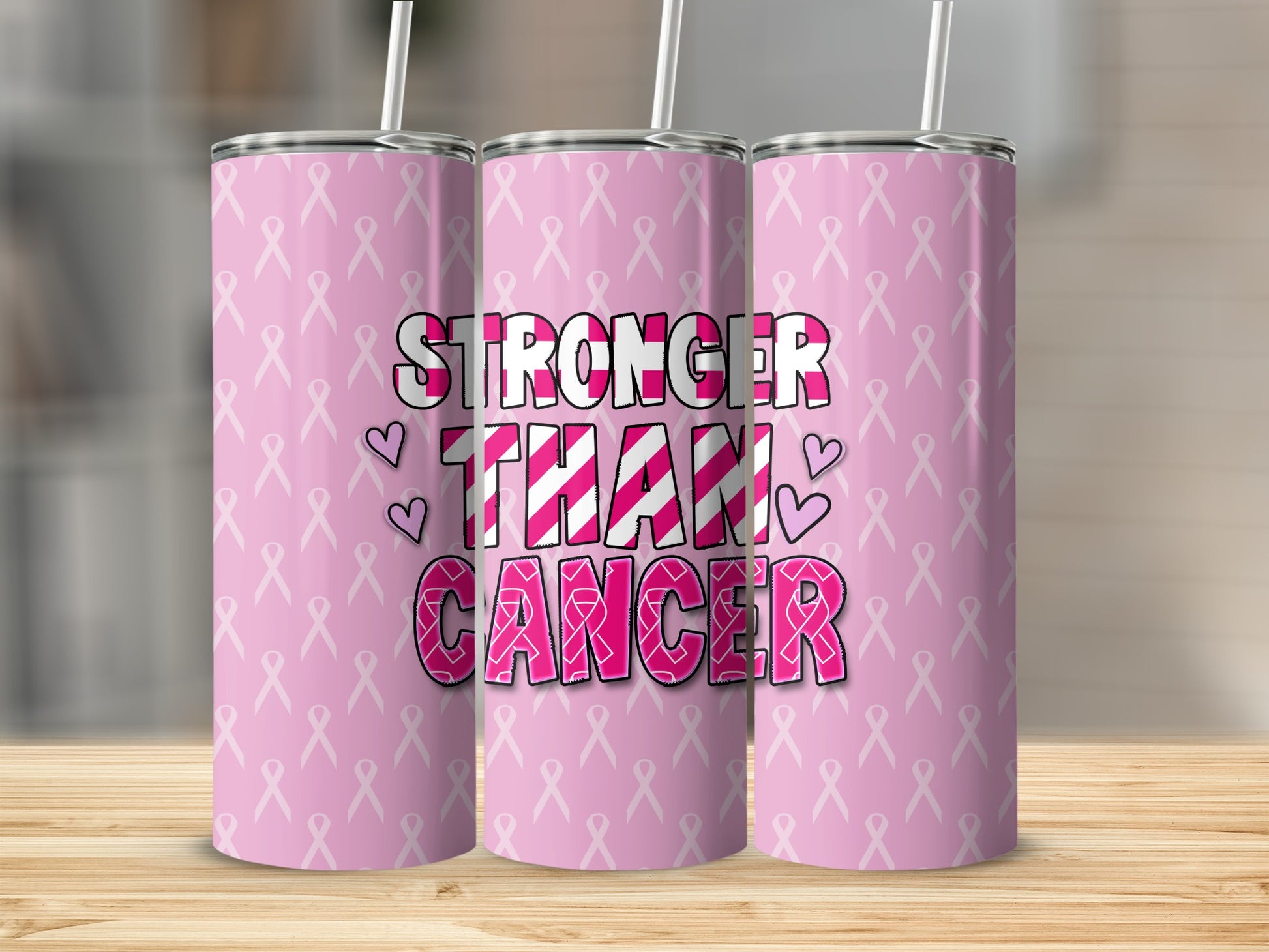 Pink tumbler with "Stronger Than Cancer" text and ribbon pattern.