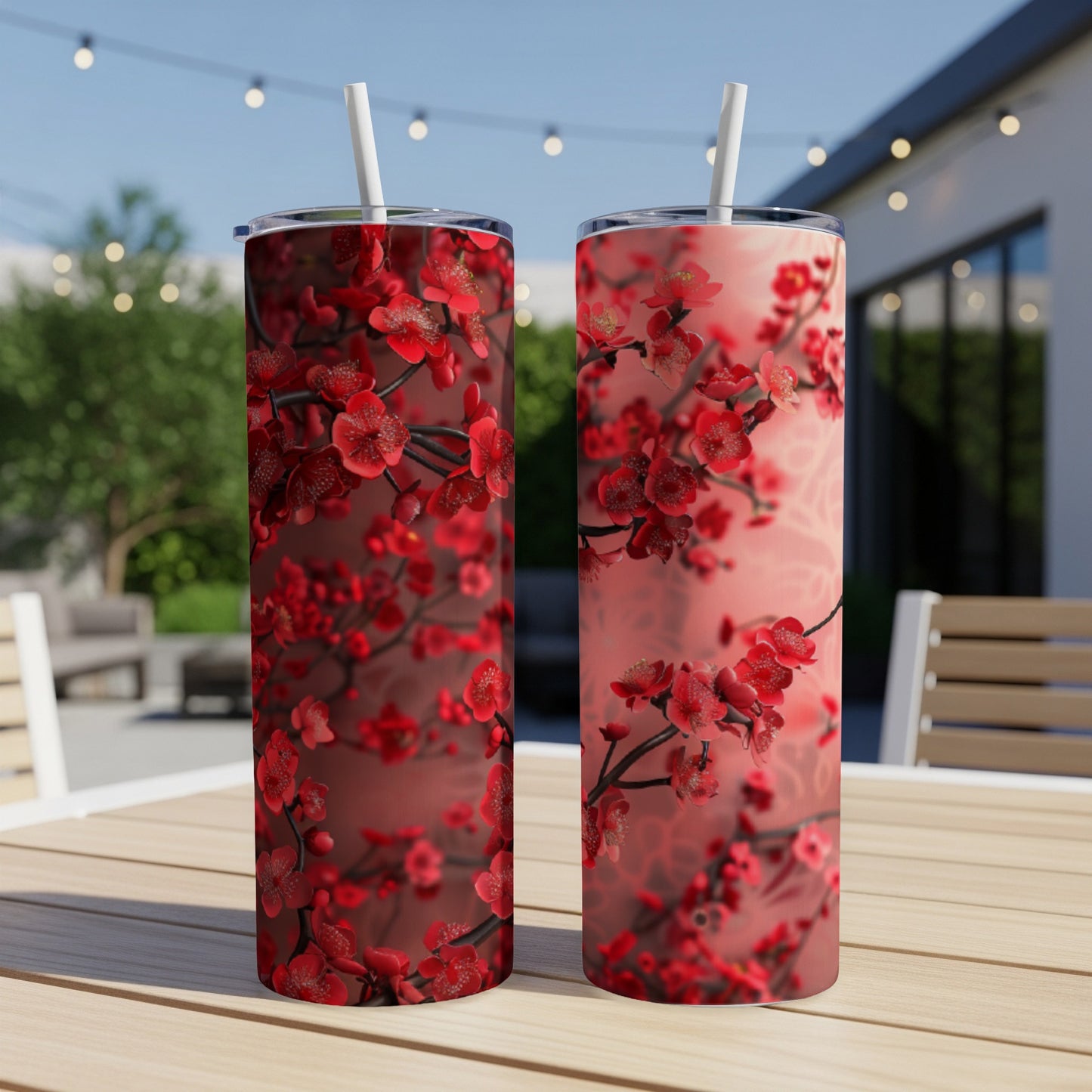 Two tall tumblers with a red floral pattern sit on a table.