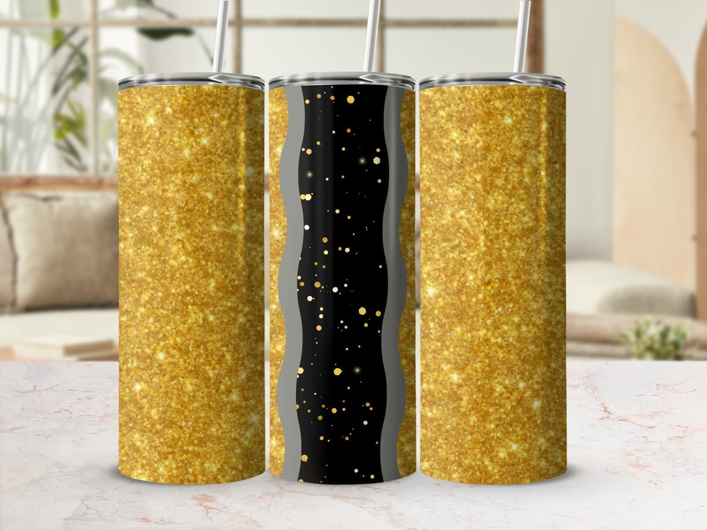 Three glitter tumblers on a marble surface, two gold glitter, one black with gold specks.