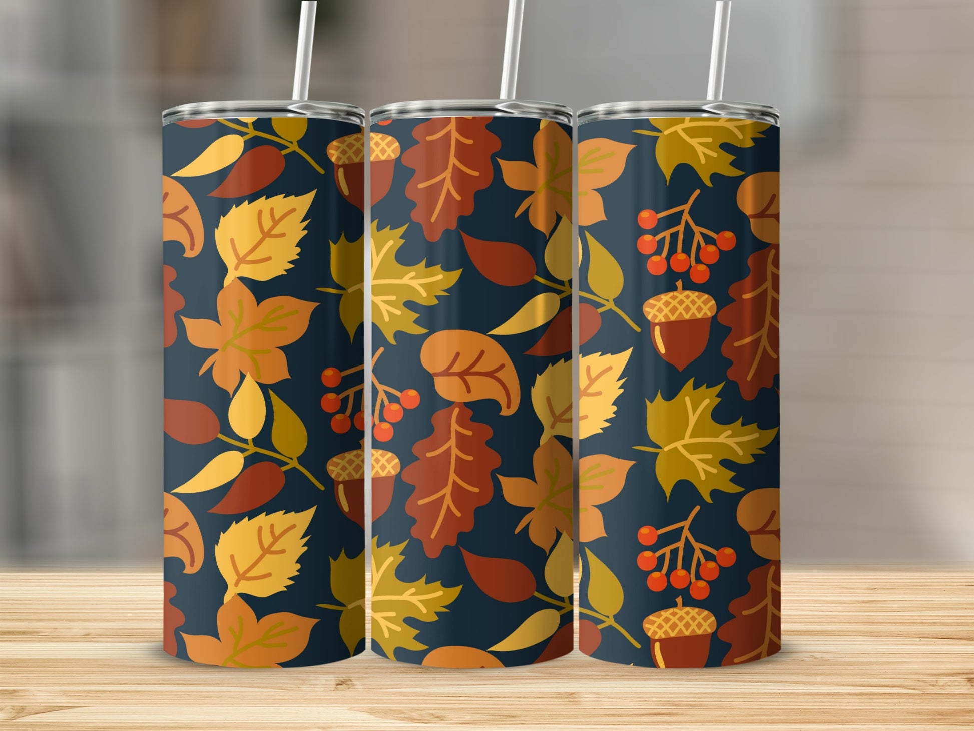 Three tumblers with fall leaves, acorns, and berries on a dark blue background.