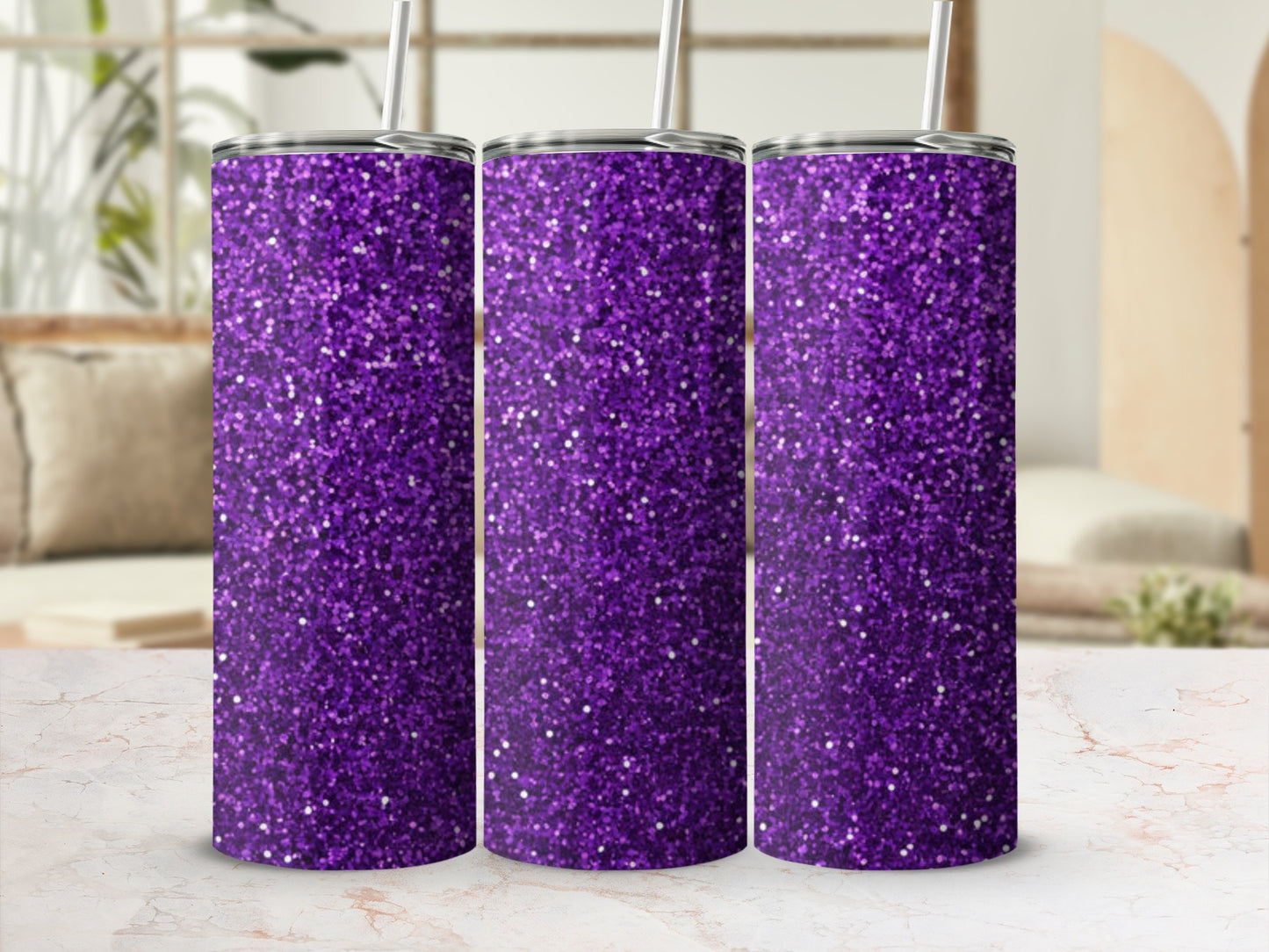Three purple glitter tumblers with straws on a marble countertop.