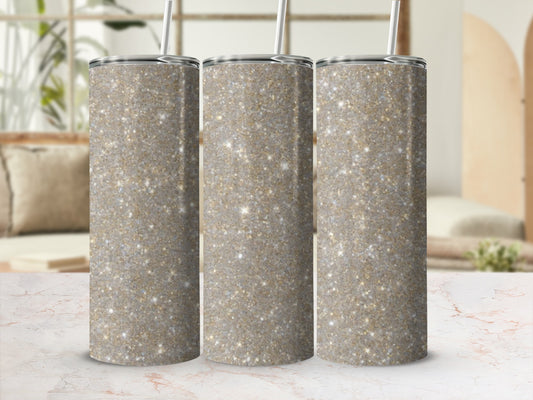Three sparkly glitter tumblers with straws on a marble countertop.