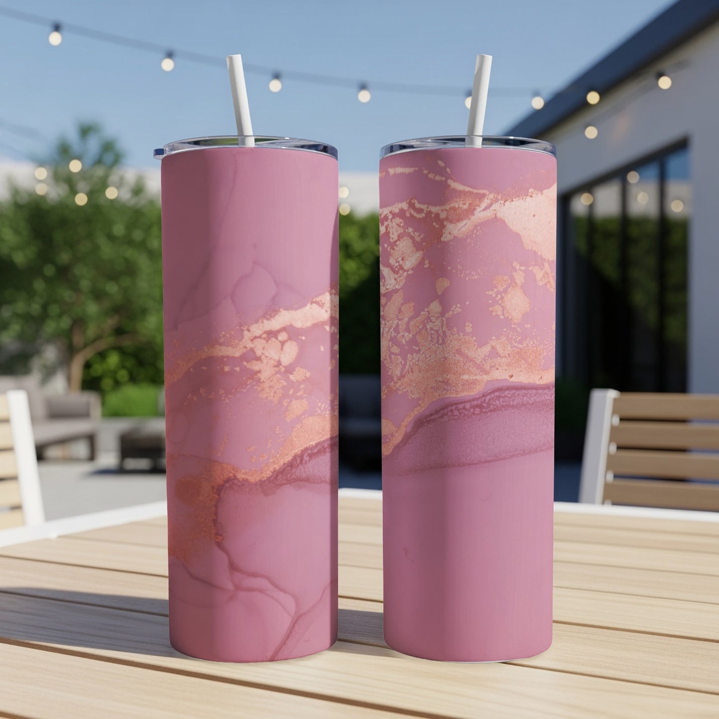 Two pink tumblers with marble and rose gold accents on a wooden table.