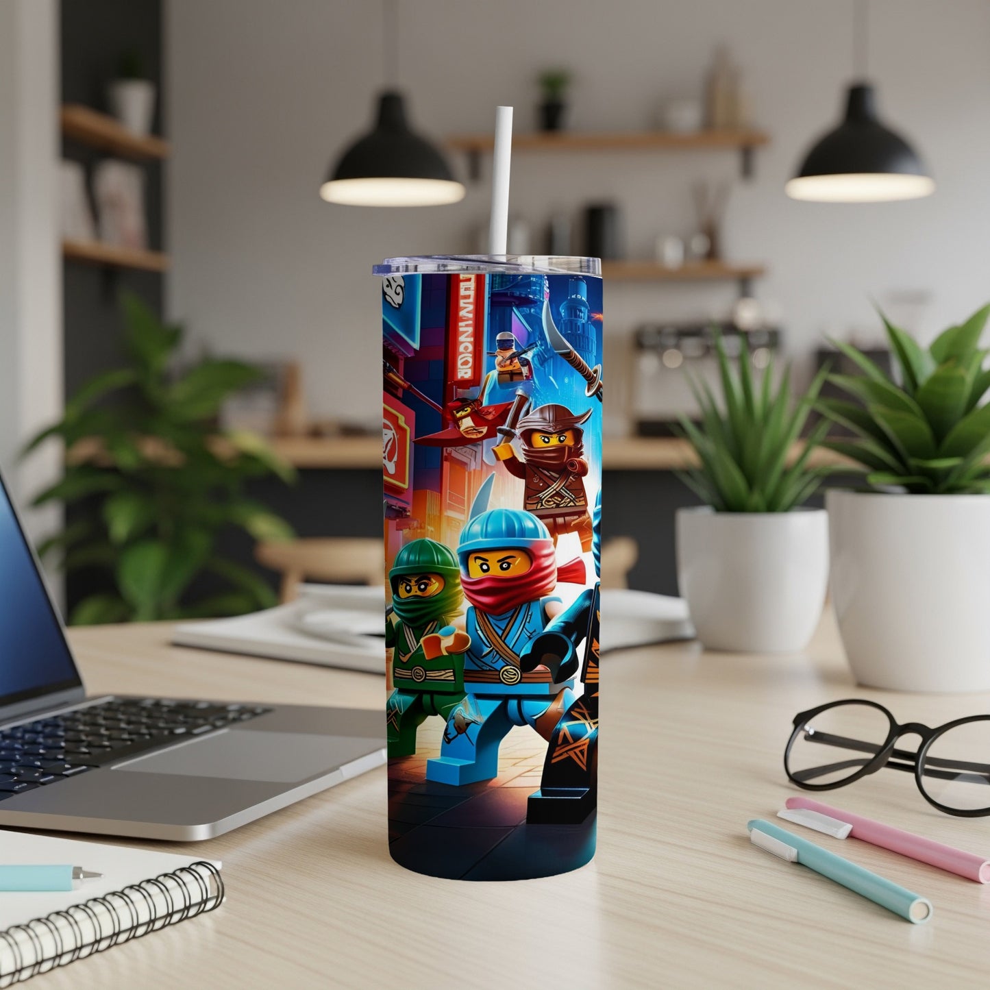 Ninjago characters on a blue tumbler with a straw, on a wooden desk.