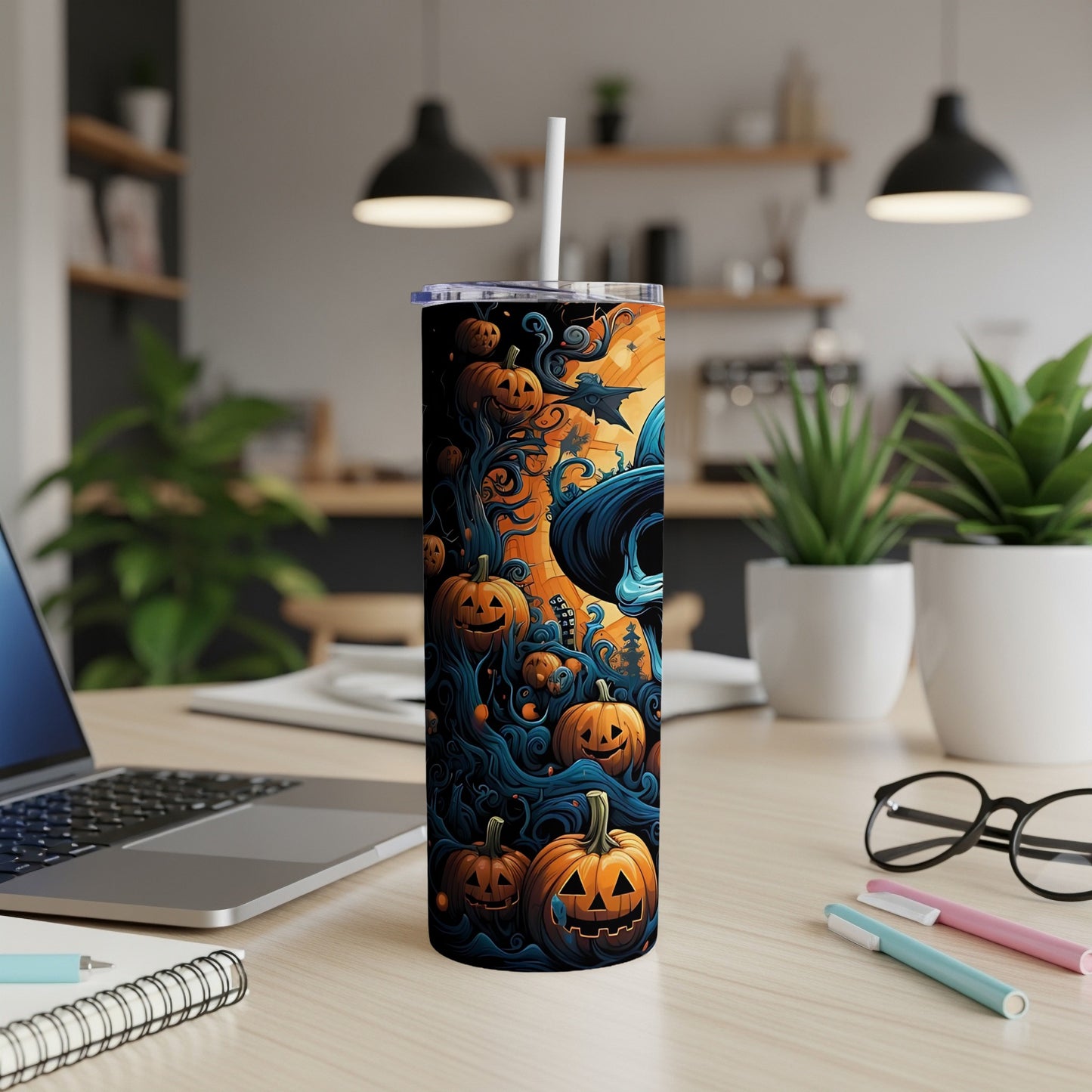 Tumbler with jack-o'-lanterns and witch hat design on a desk.